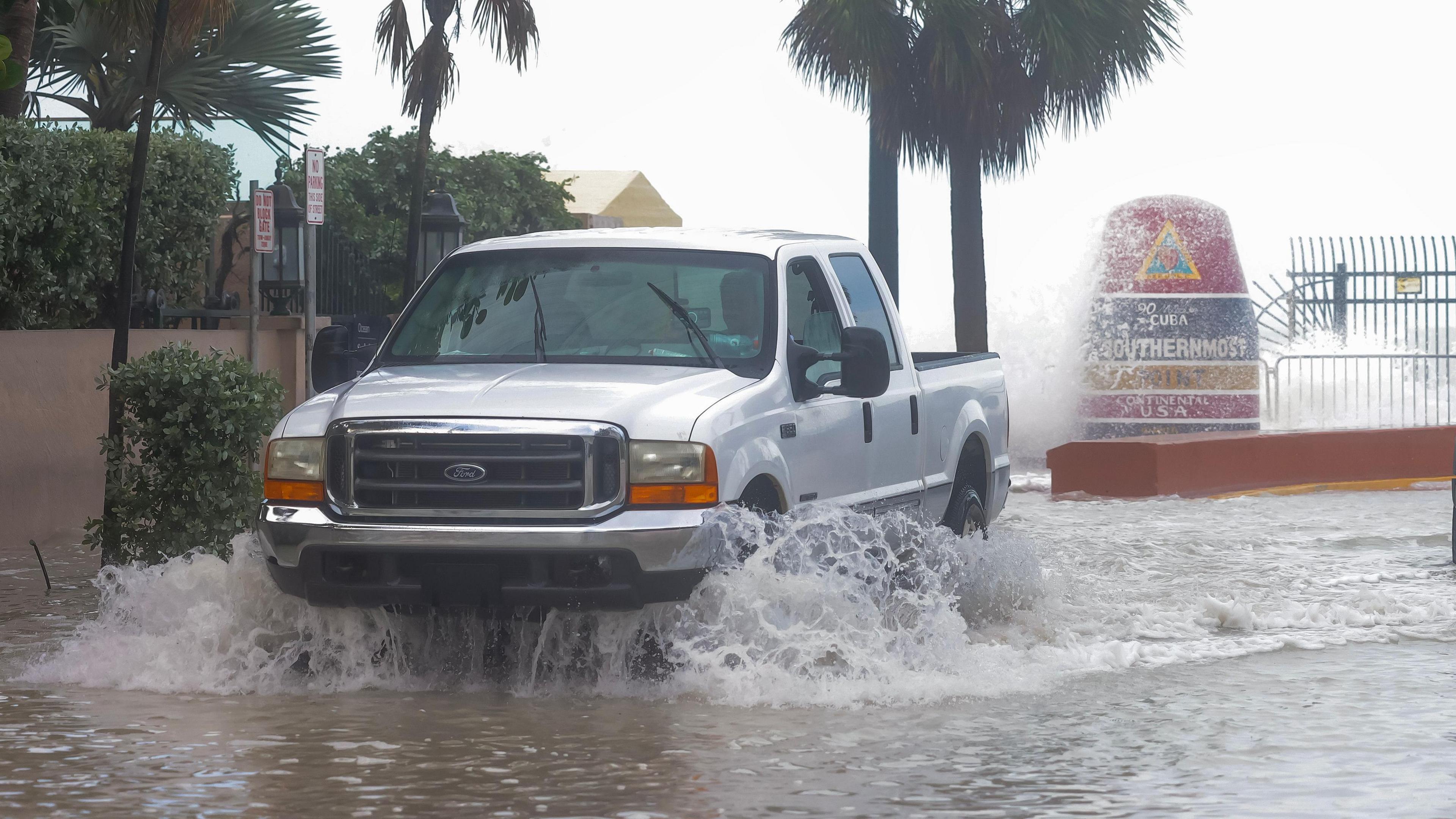 A pick-up truck drives through flood water