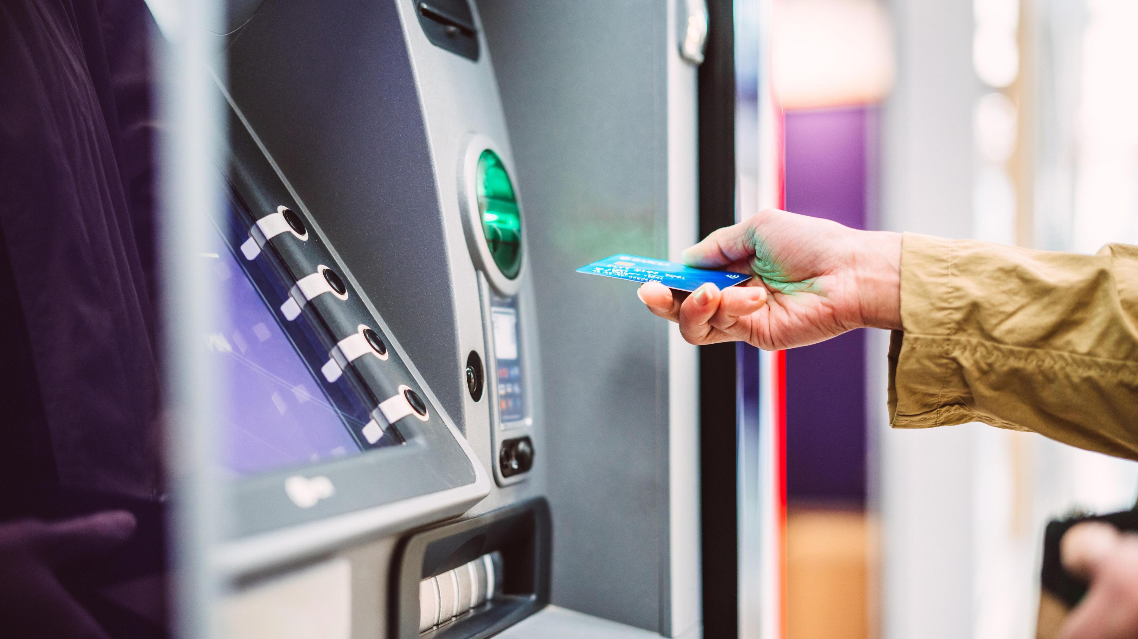 A woman using a cash machine to make a cash withdrawal.