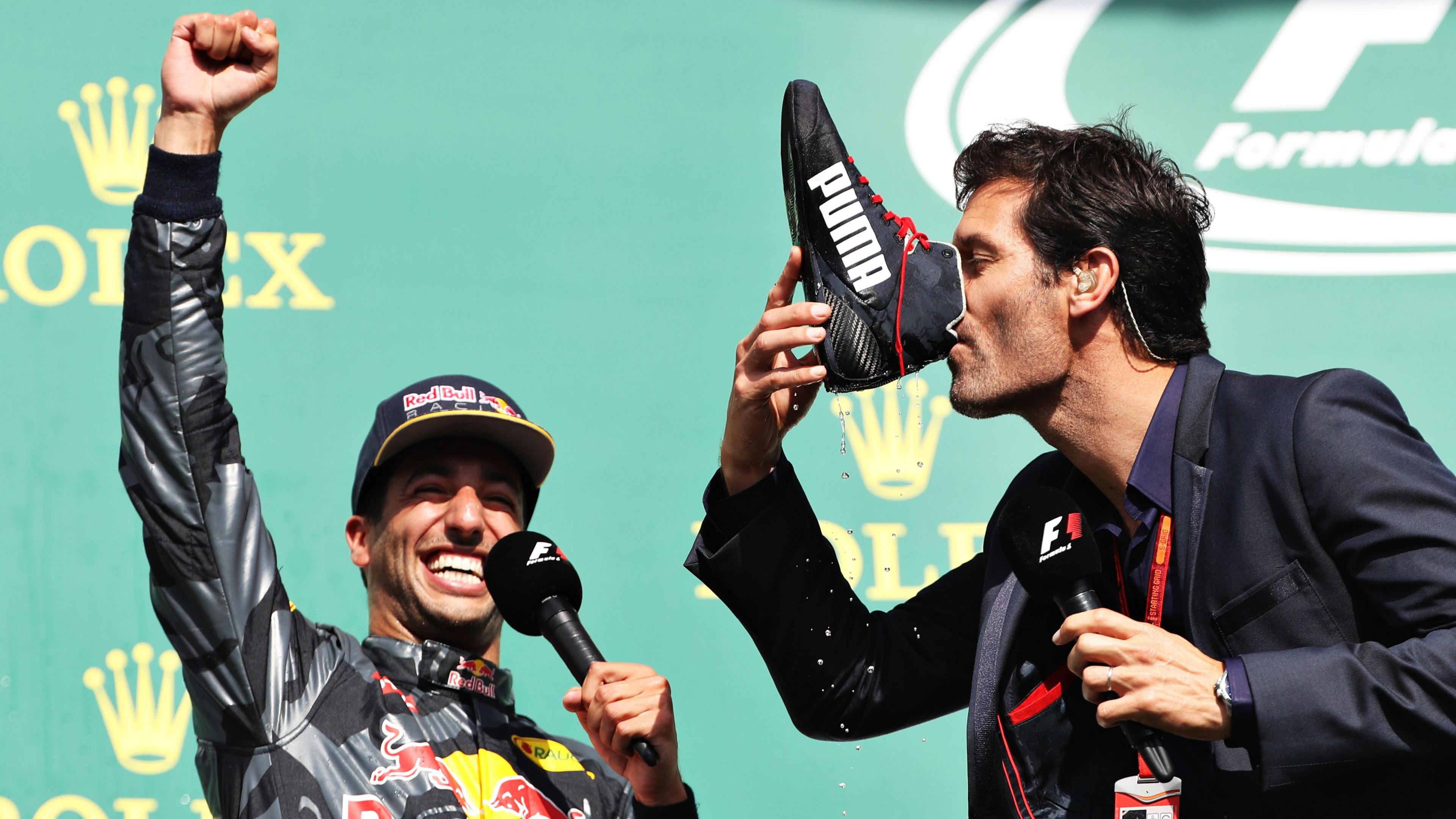 Daniel Ricciardo celebrates as Mark Webber does a shoey.