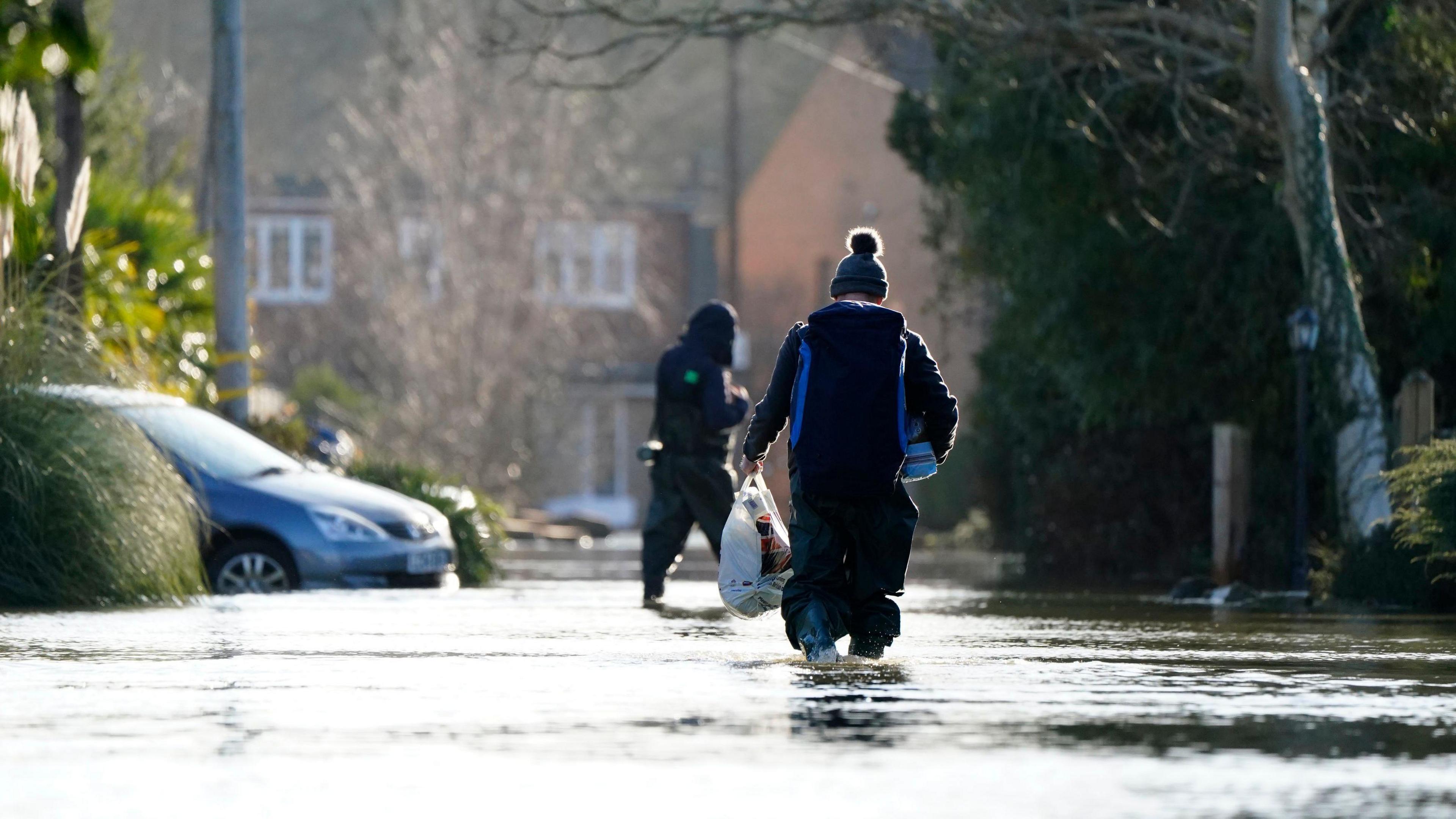 A person walking through floodwater