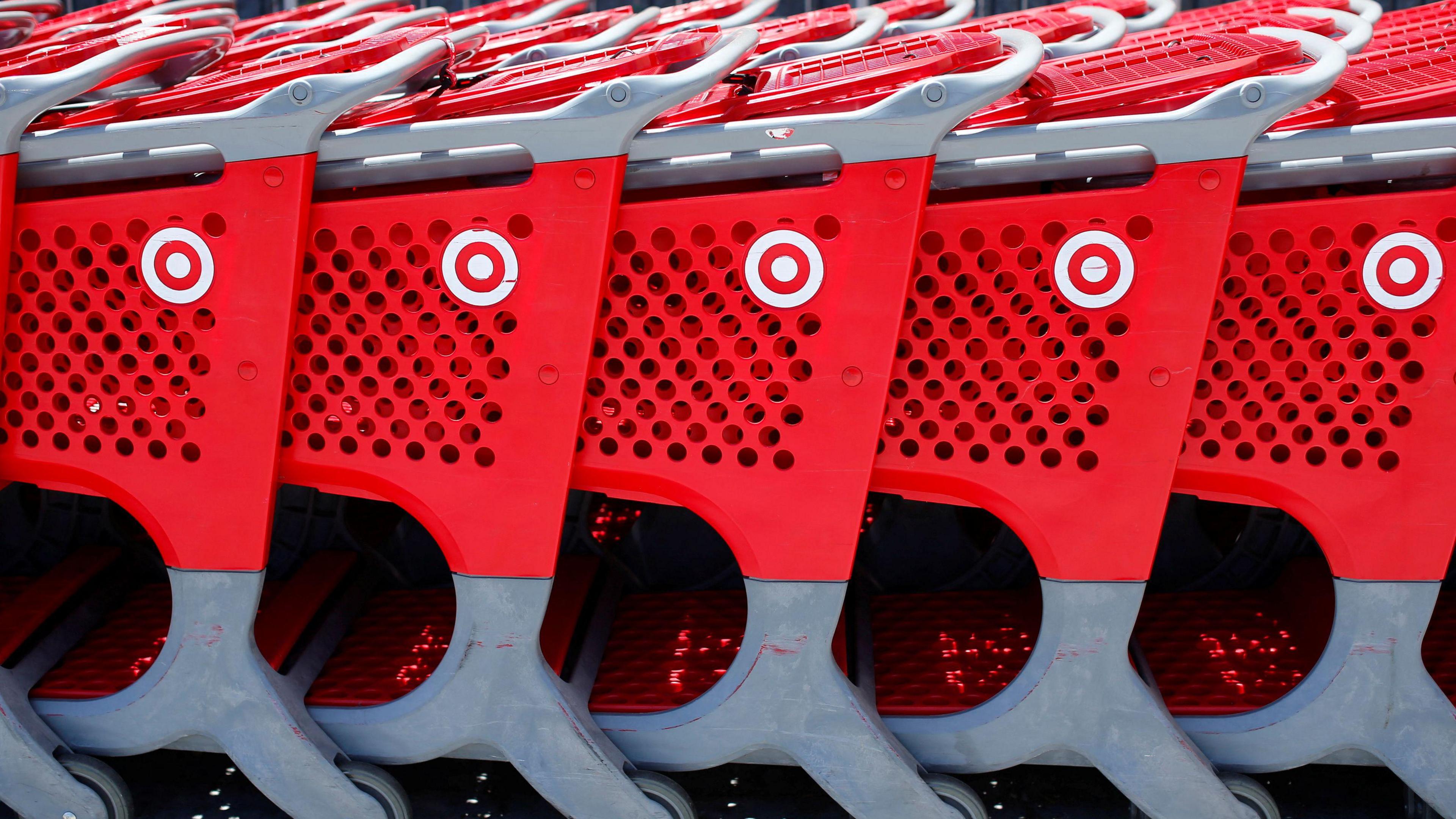 Five red shopping carts with Target logos are lined up outside.