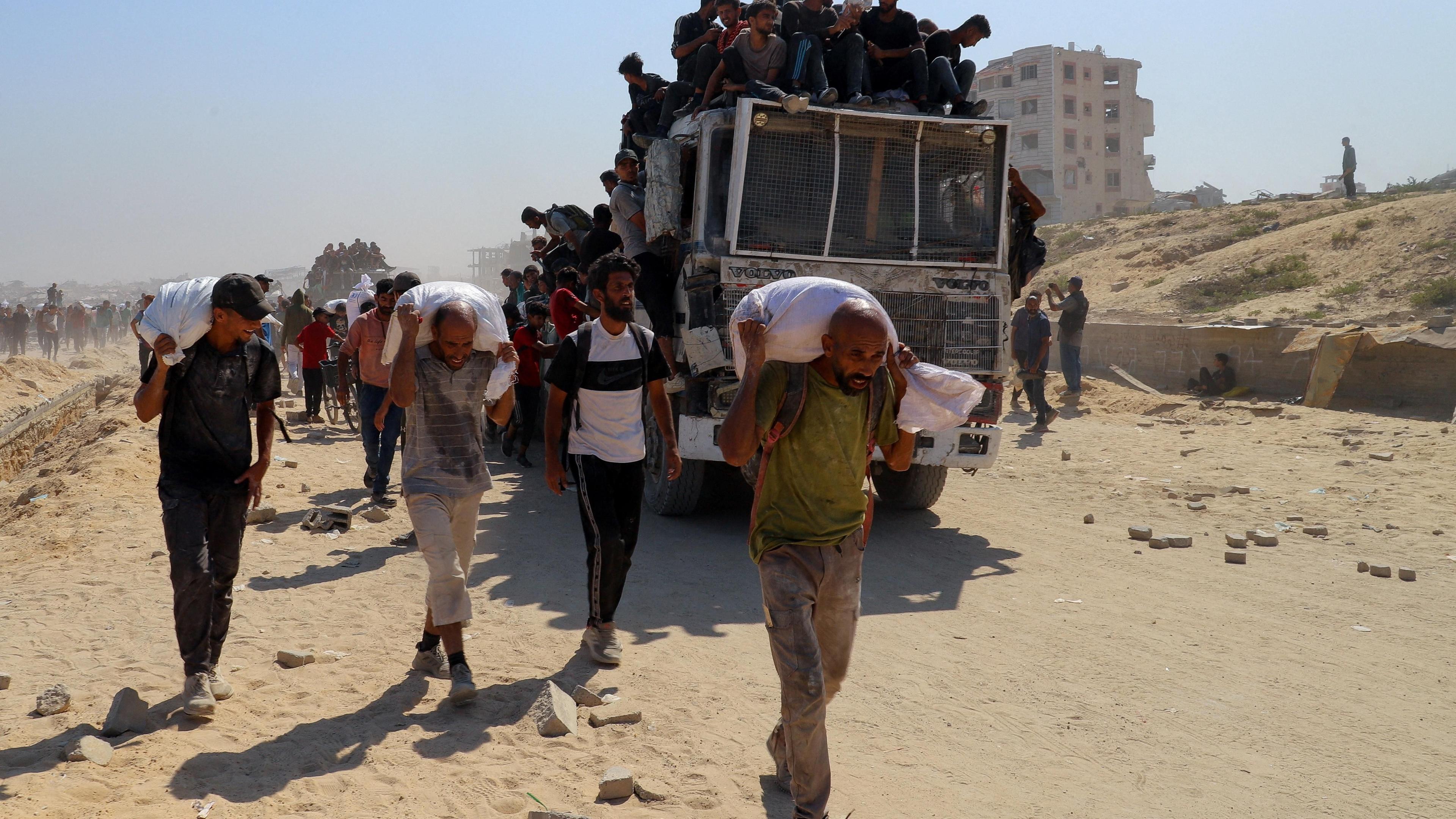 Palestinians carry aid supplies that entered Gaza through Israel.