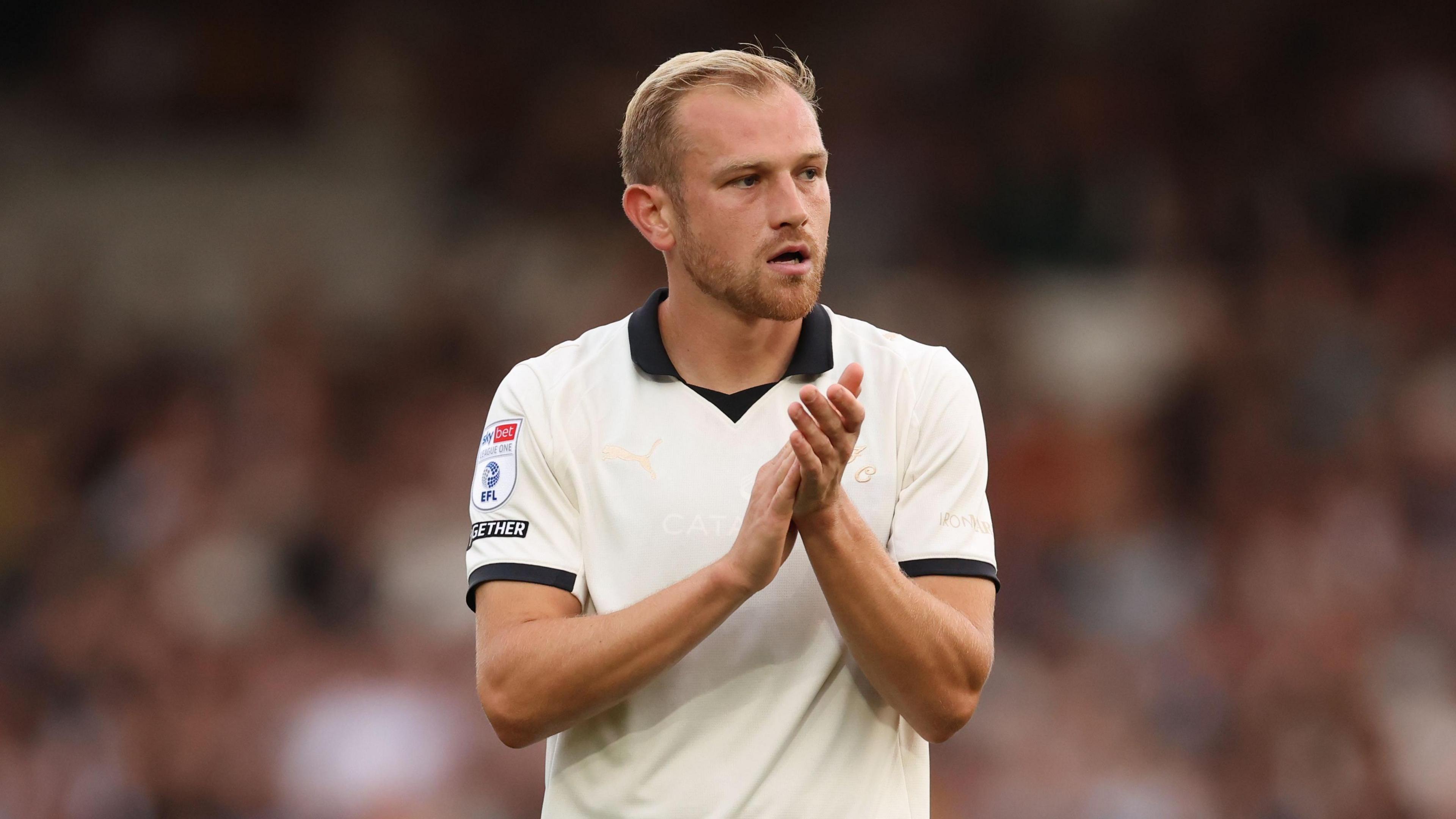 Ryan Croasdale in his white Port Vale shirt claps the fans 