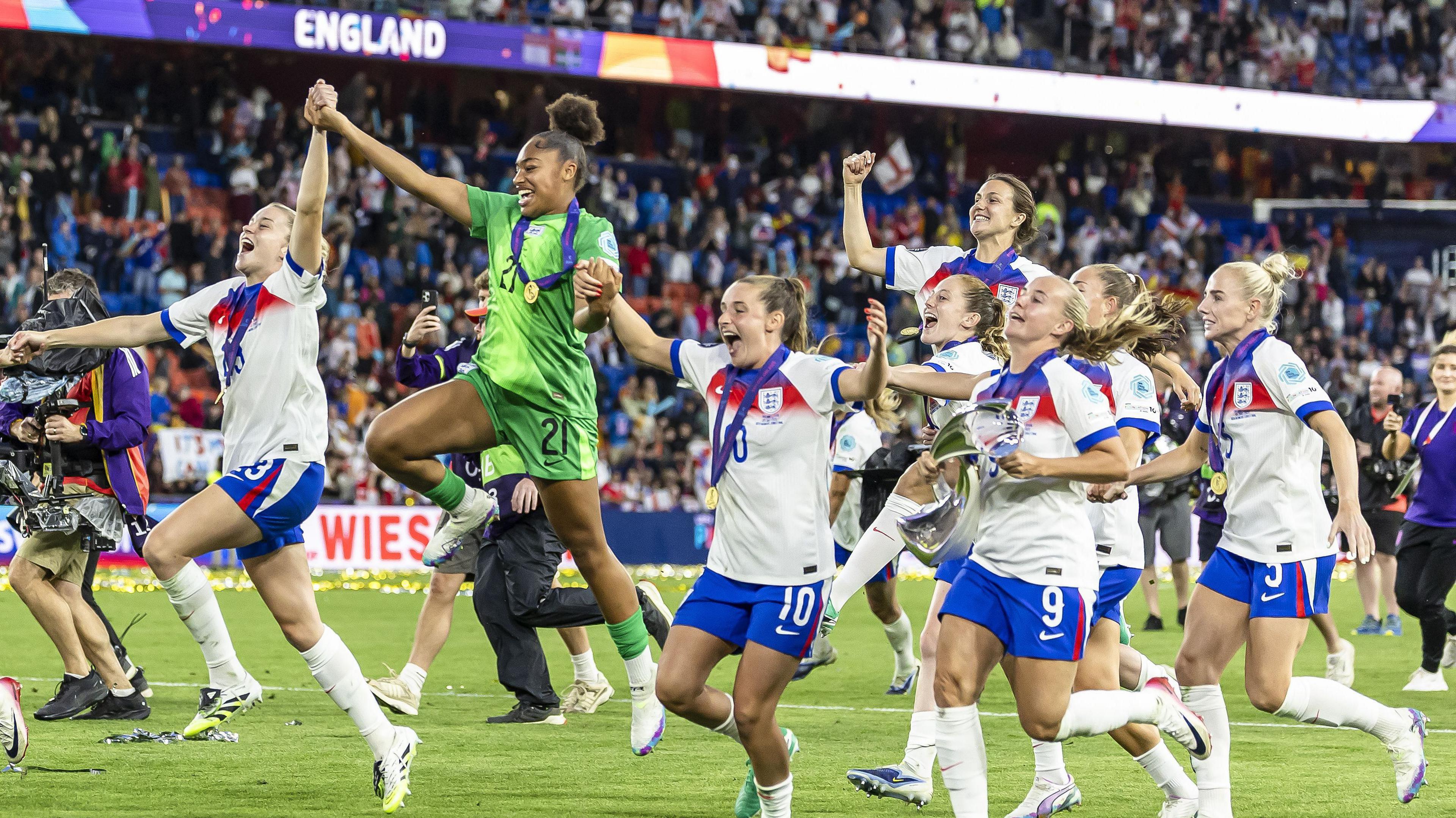 england team celebrate holding hands and leaping into the air