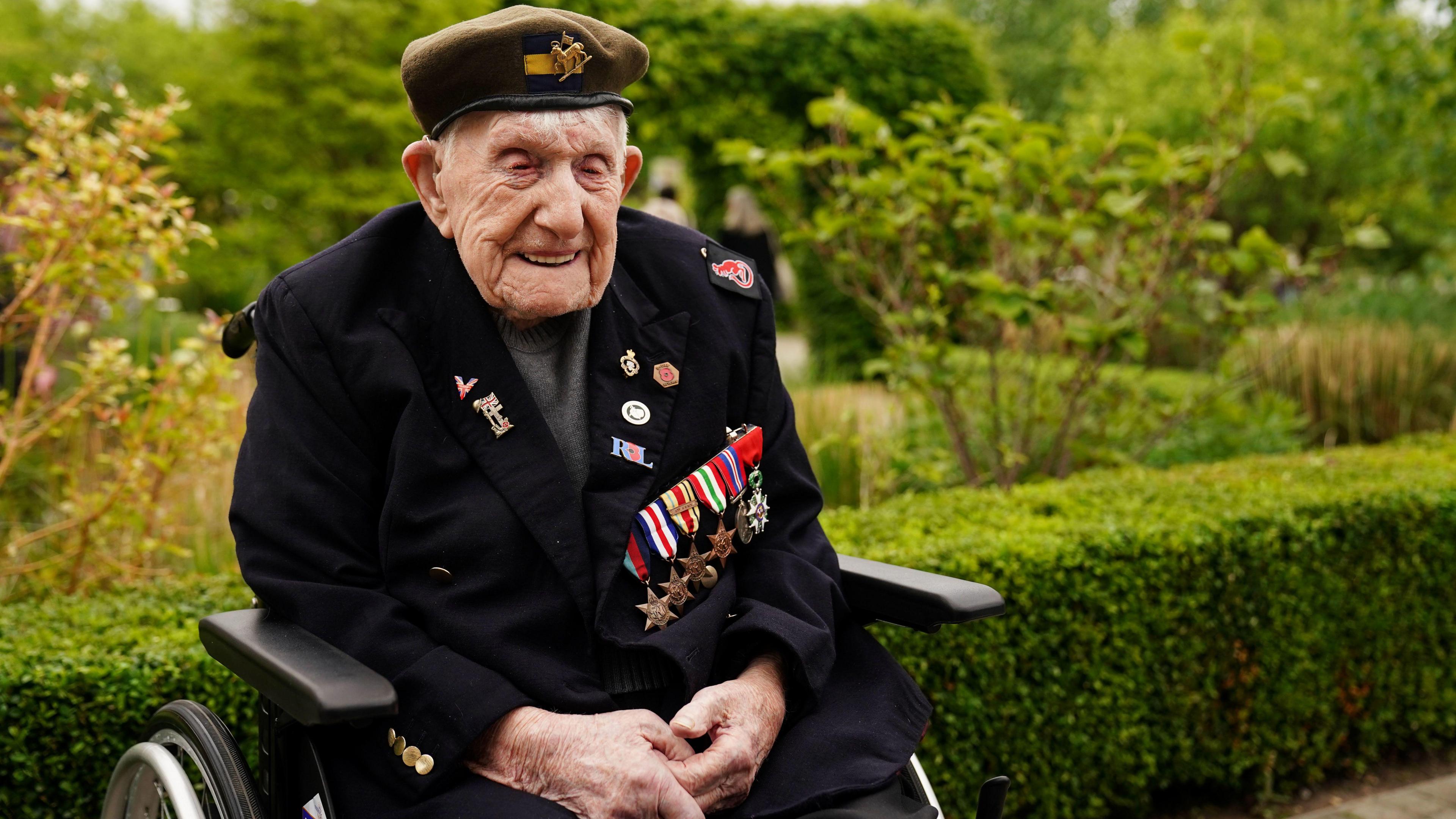 Donald Rose wearing his medals in a wheelchair