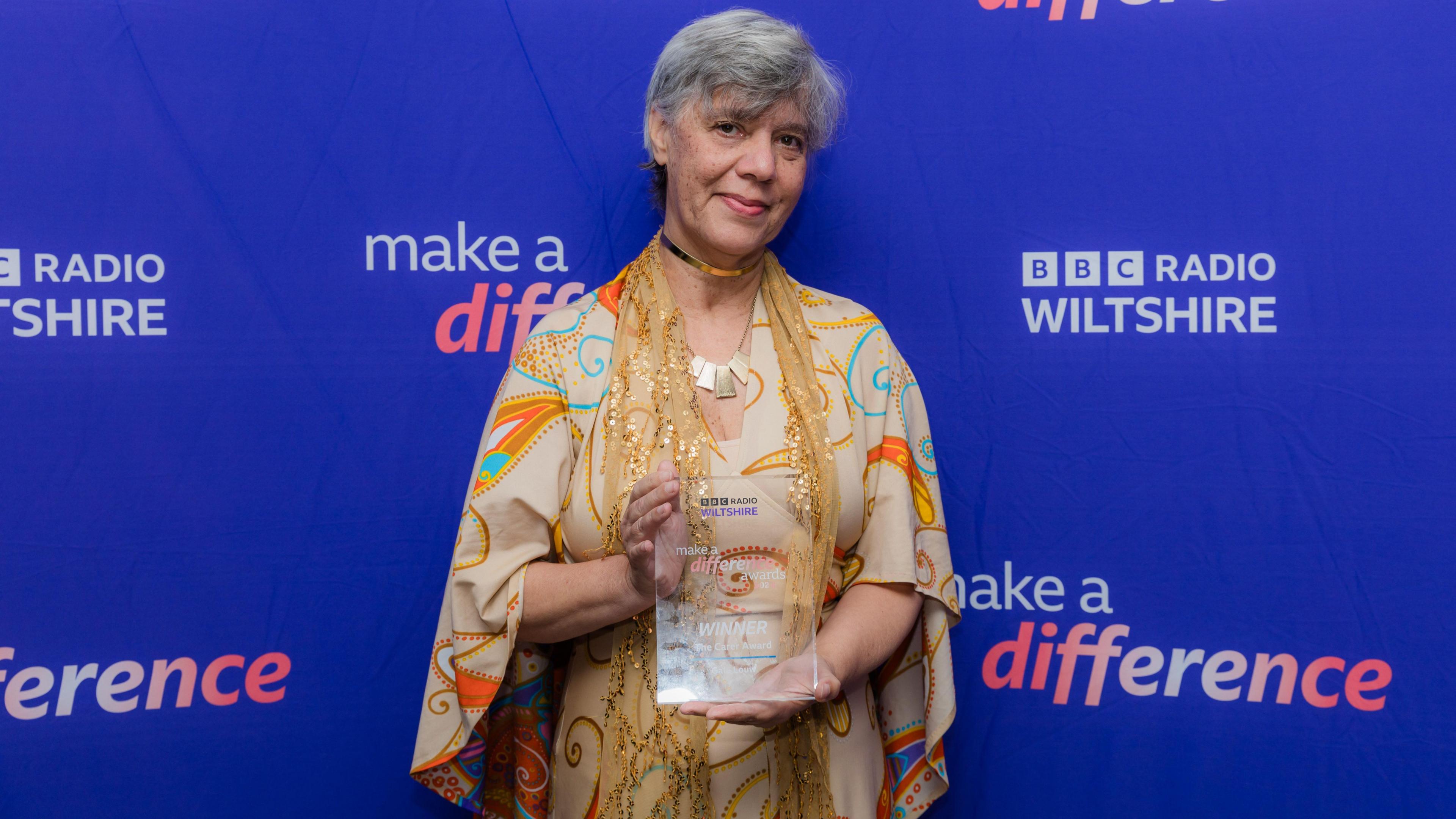 Gale holding her award in front of the BBC Radio Wiltshire banner