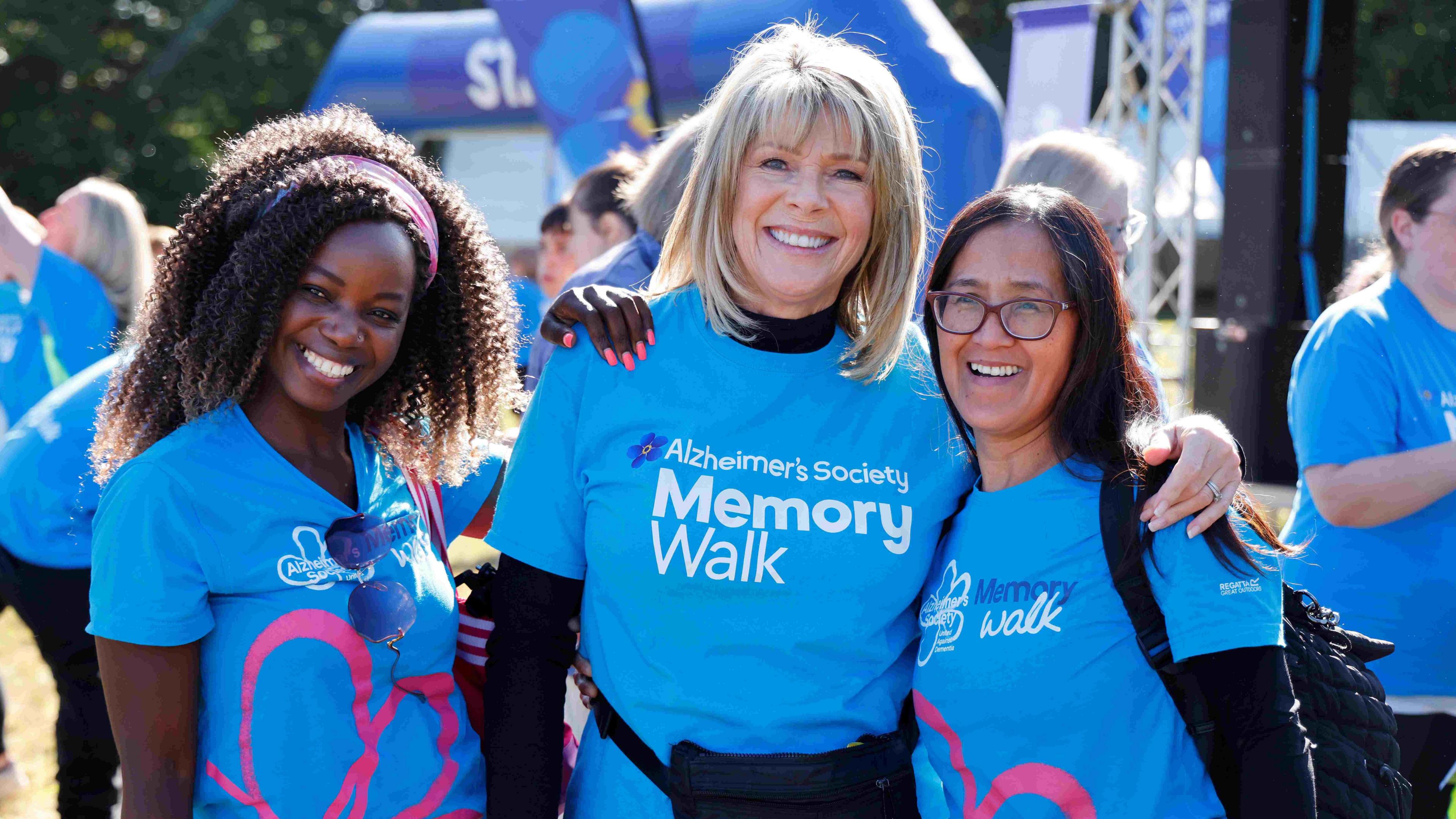 Ruth with two other female fundraisers wearing Memory Walk blue t-shirts and smiling at the camera