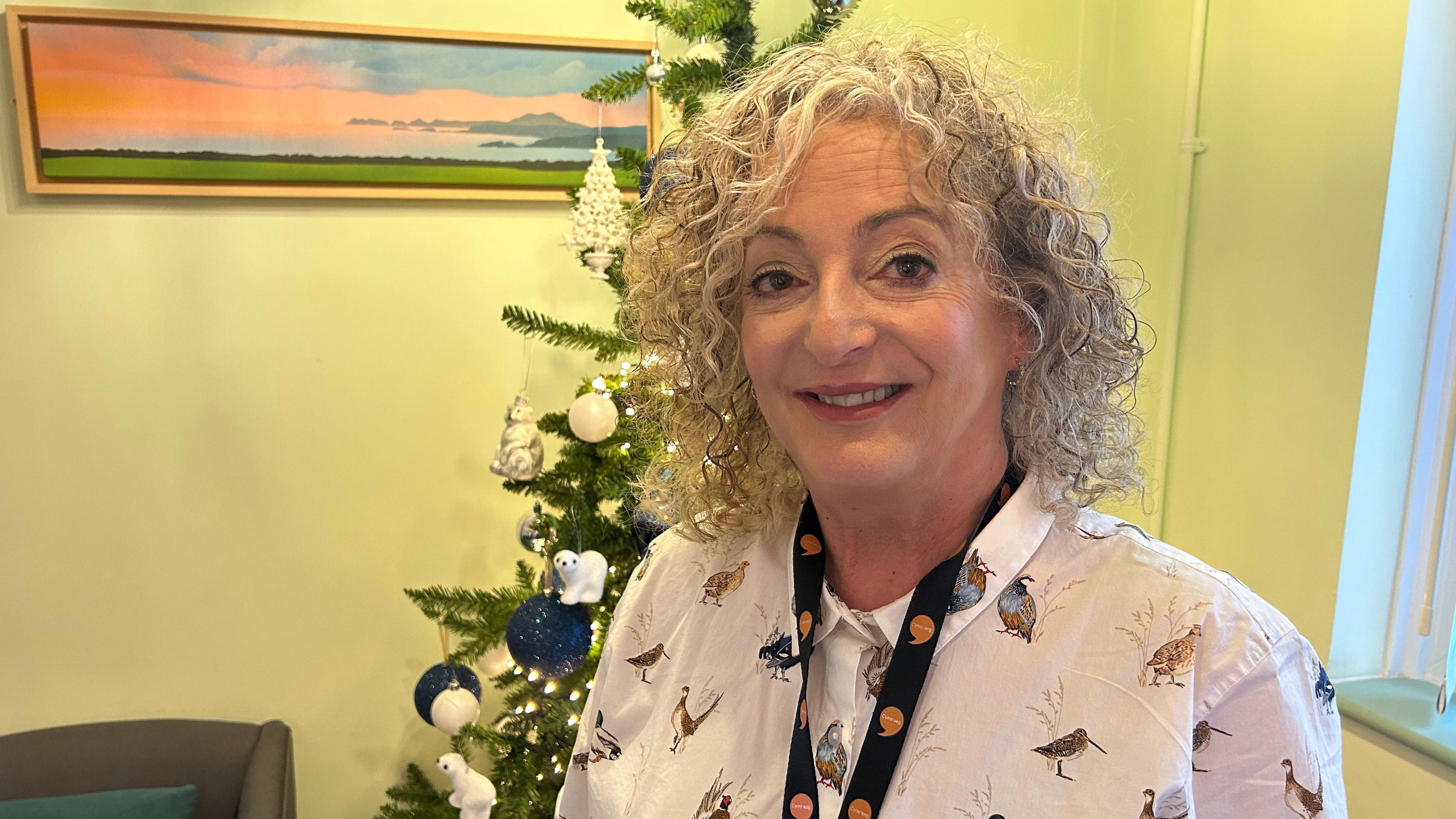 Bethan Thomas o flaen y goeden Nadolig