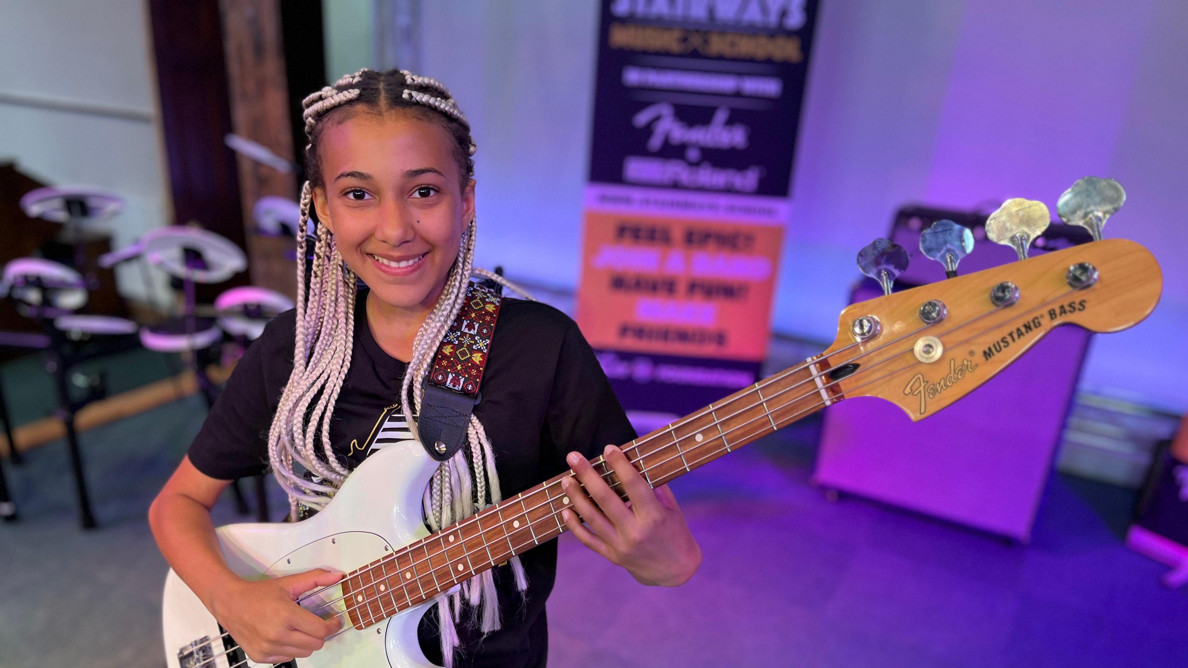 Nandi Bushell playing a bass guitar