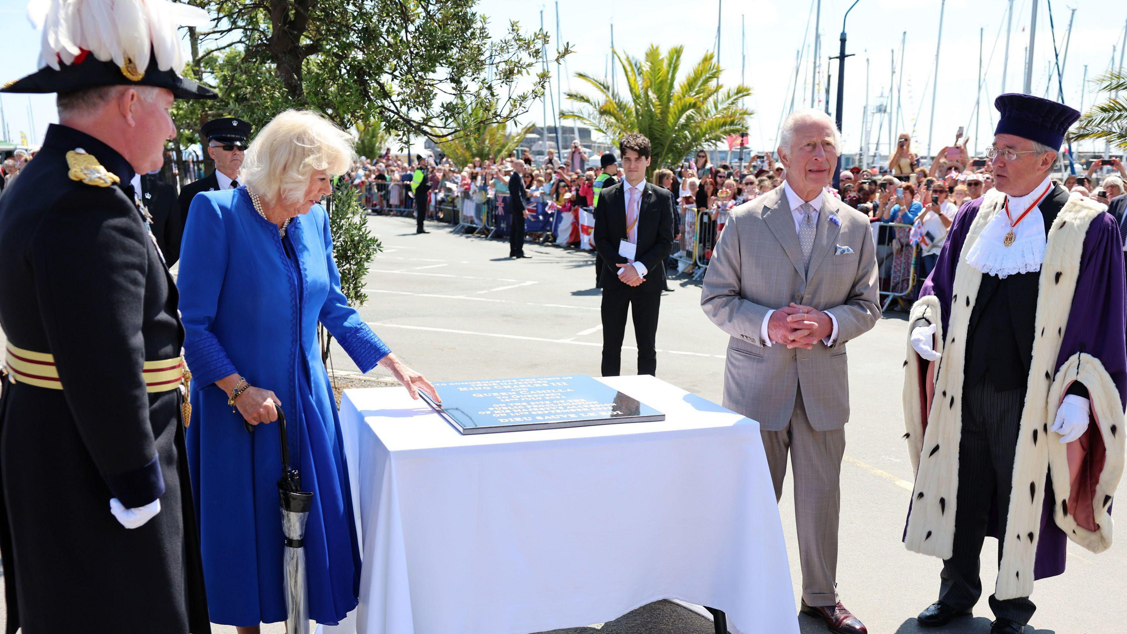 King Charles III and Queen Camilla unveil a plaque in honour of their visit while touring a showcase of Guernsey culture, heritage, produce and environmental initiatives on Crown Pier in St Peter Port, Guernsey.