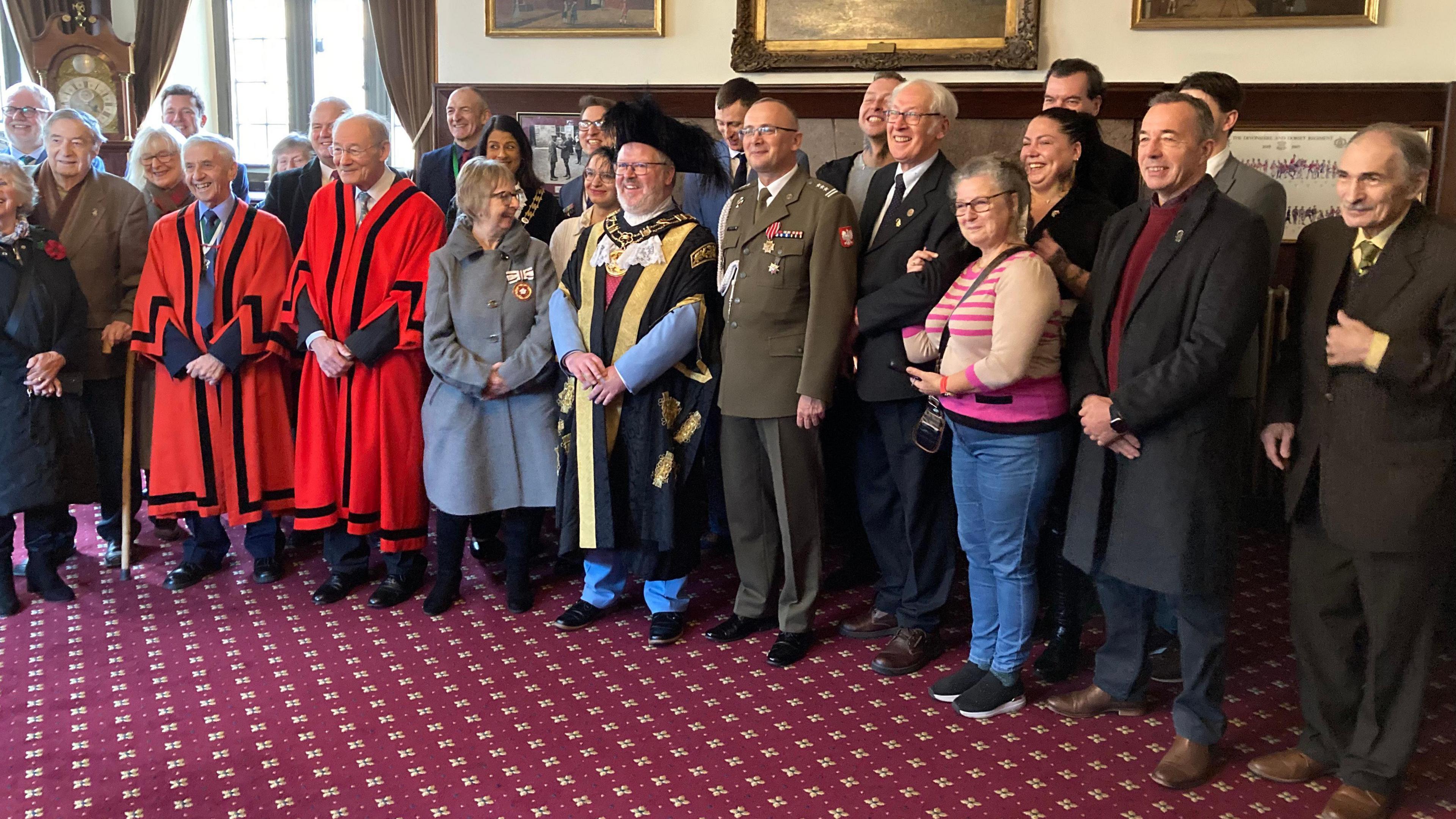 Dozens of people including Exeter's Lord Mayor pose for a group photograph in Exeter's Guildhall after a flag raising ceremony.