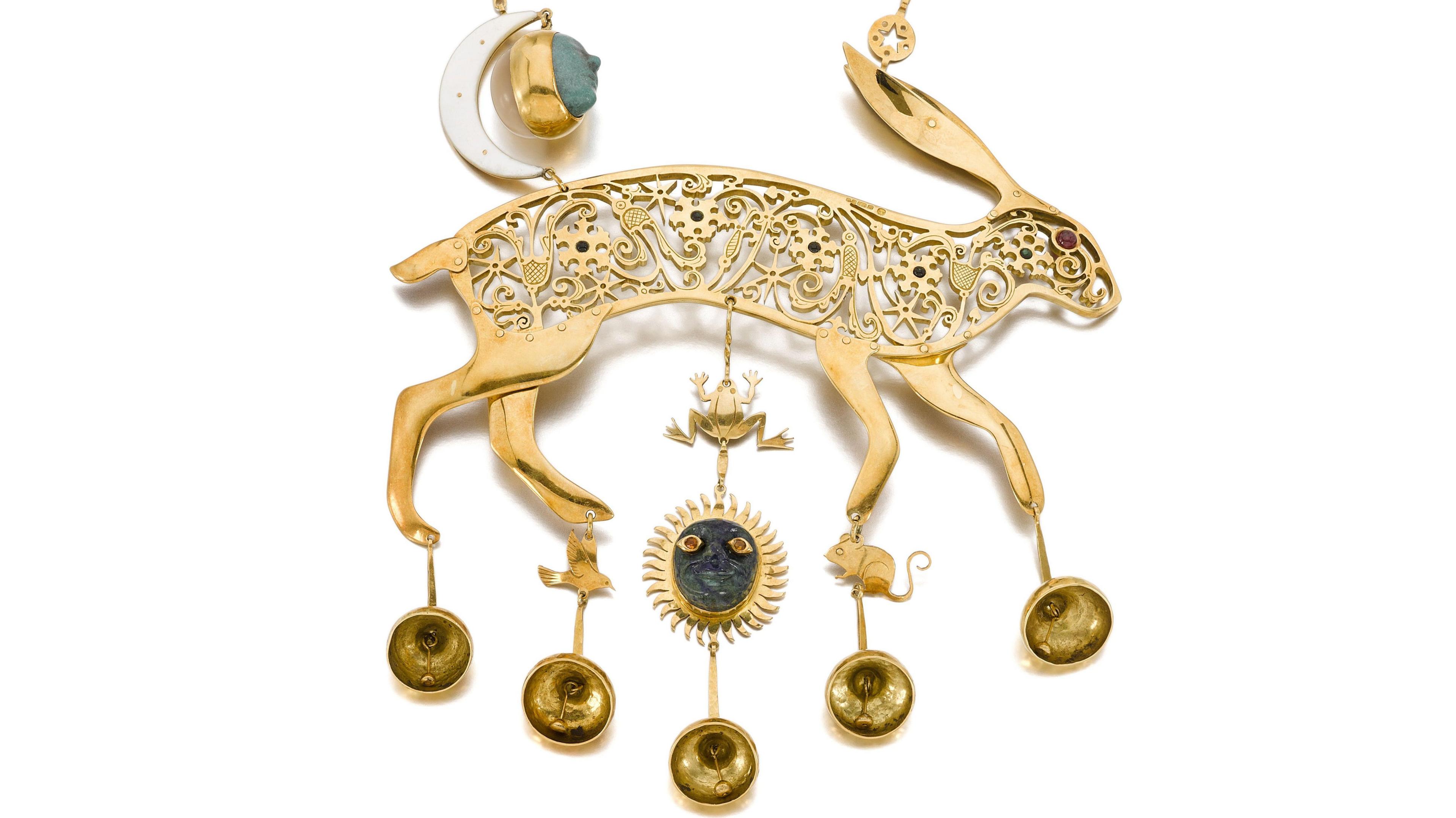 A golden hare decorated with jewels and shapes of flowers, a frog and a sun.