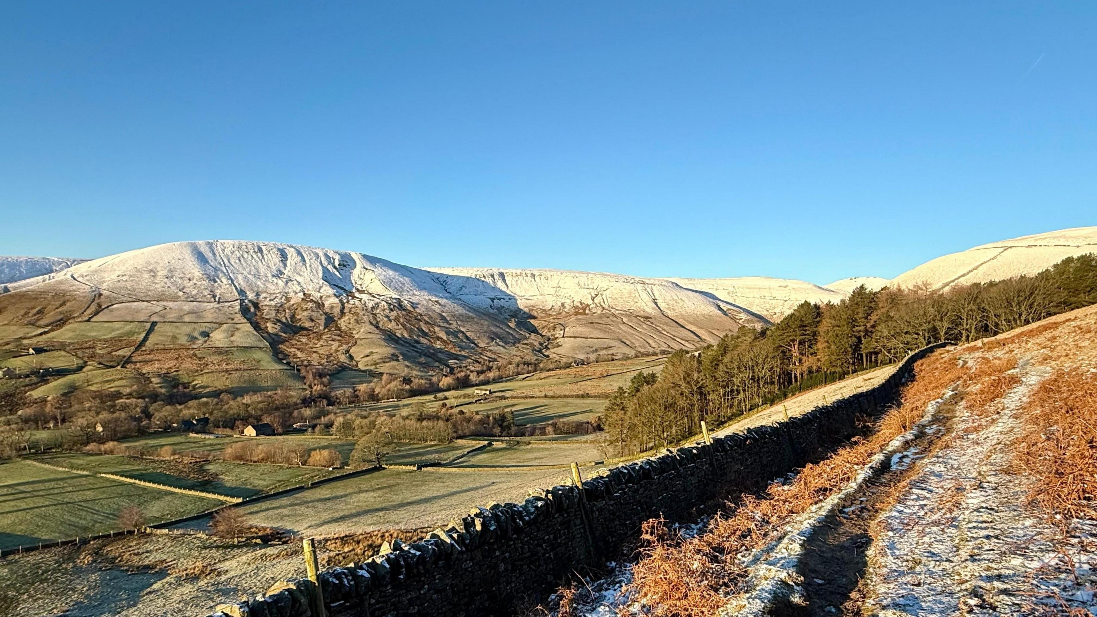 hills and mountains covered with some snow where the valley is snow free and looking greeen