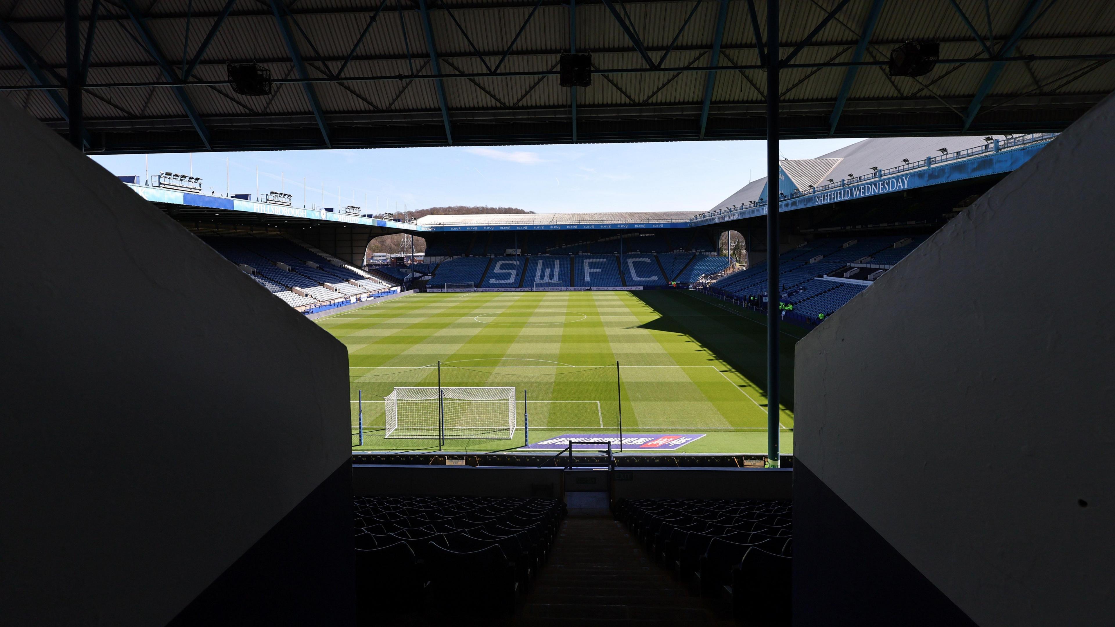 Sheffield Wednesday's Hillsborough stadium from an entrance tunnel to the stadium, with sunlight shining over the stadium