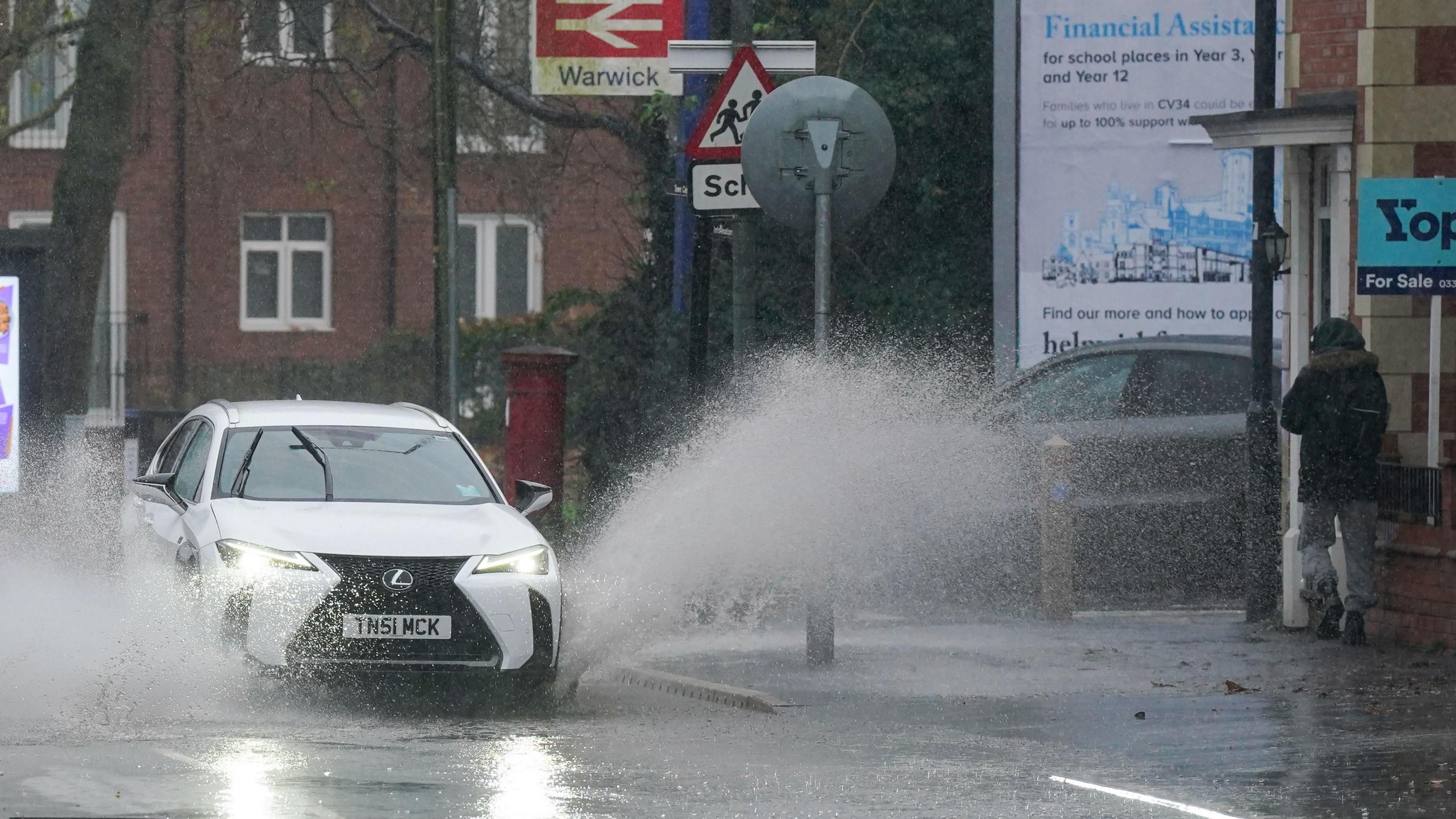 A vehicle is driven through floodwater after heavy rain in Warwick, more than 200 flood alerts are in place in the UK as Storm Bert continues to sweep across the country.