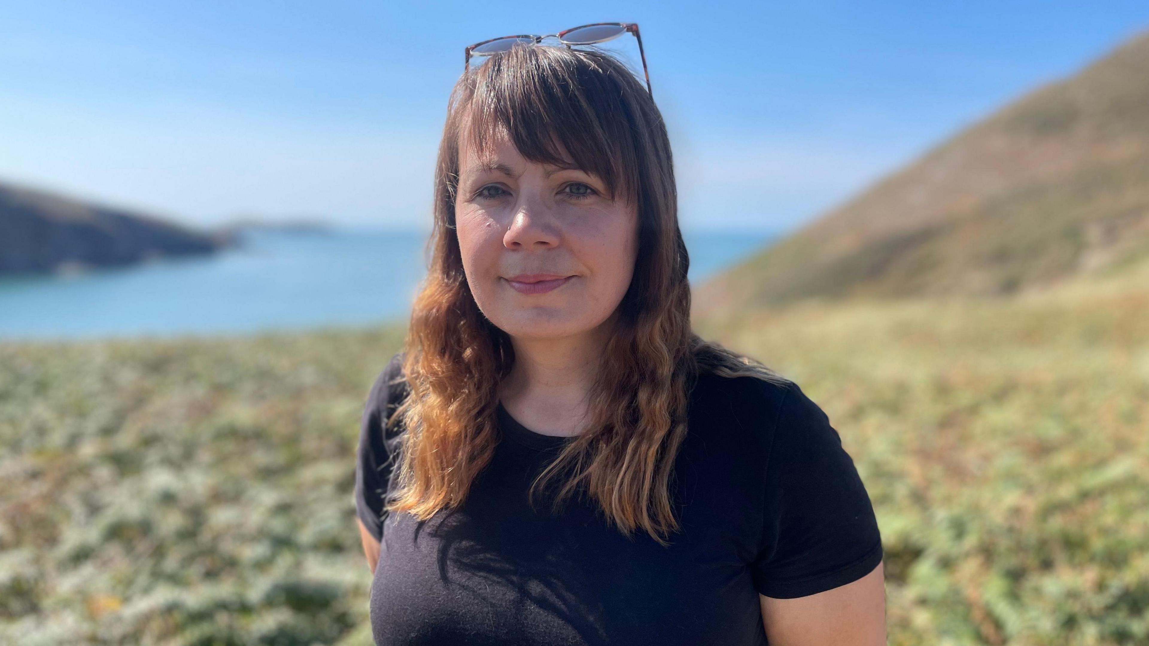 Mae Vicky Powner yn edrych i mewn i'r camera. Mae ganddi wallt hir tonnog brown golau. Mae hi'n gwenu ac yn gwisgo sbectol haul ar ei phen. Mae hi'n gwisgo crys-t du neu las tywyll. 
