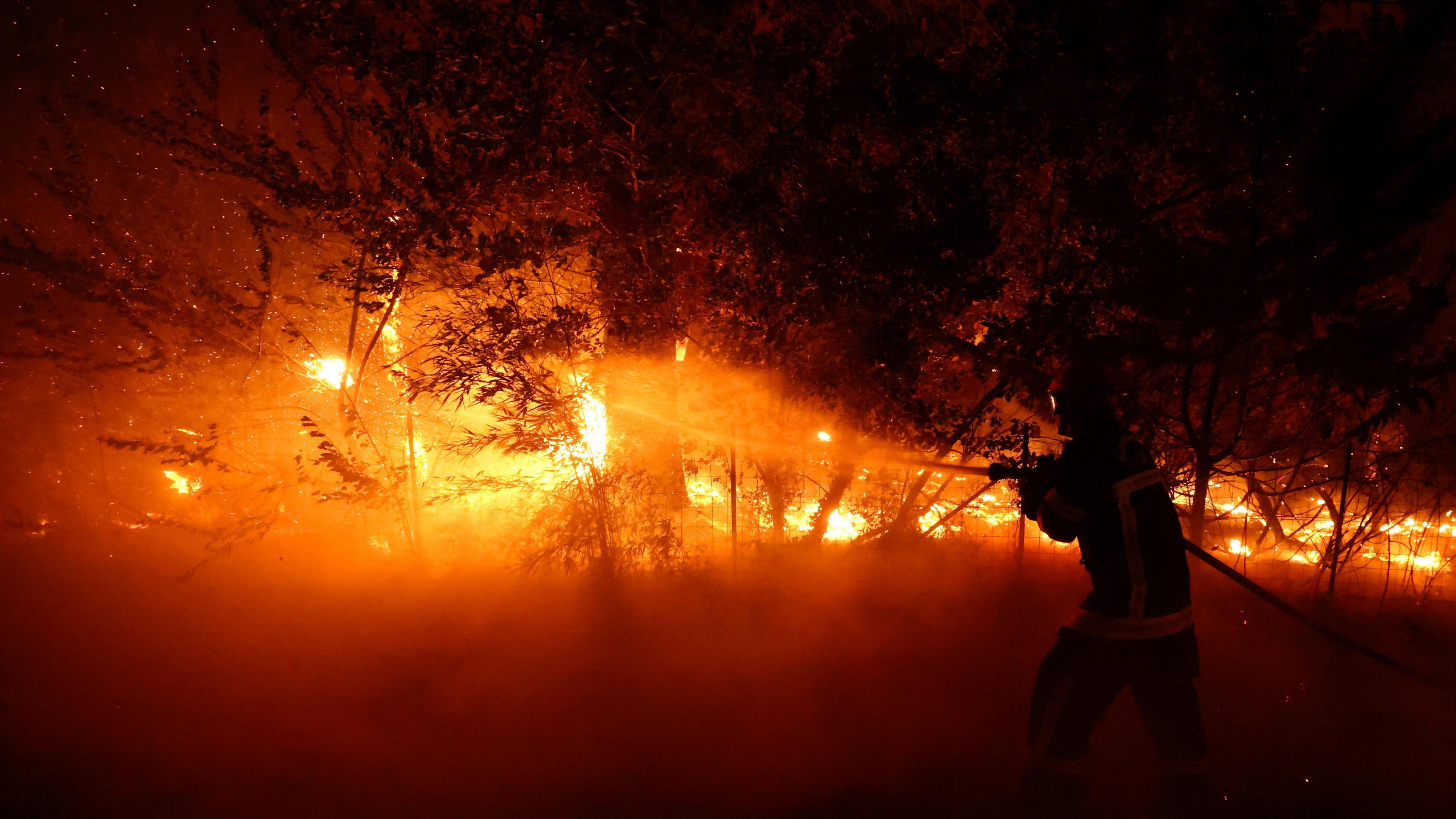 A firefighter works to extinguish flames during a wildfire in Lege-Cap-Ferret in the Gironde department.