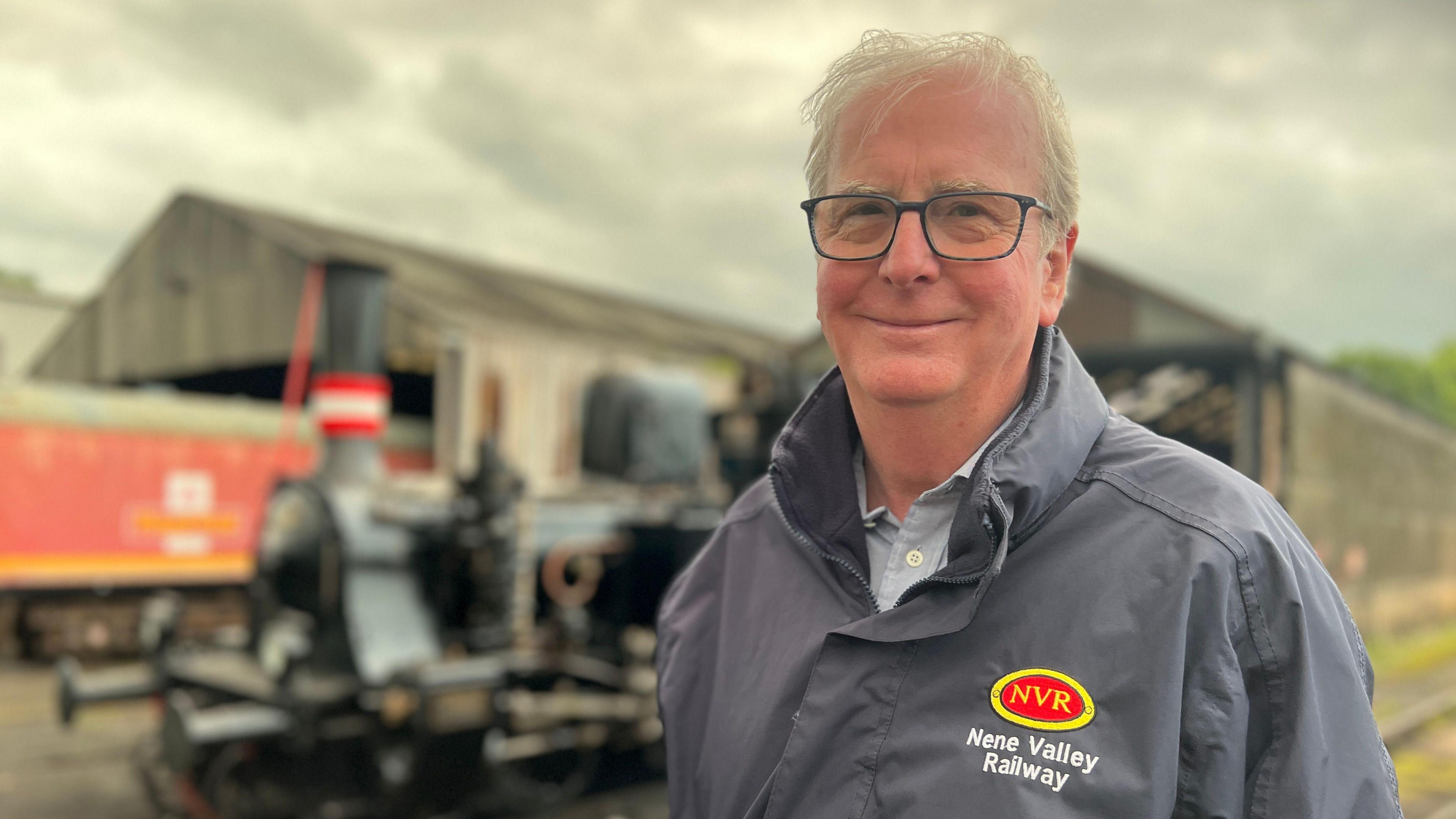 Chairman standing in front of a locomotive 