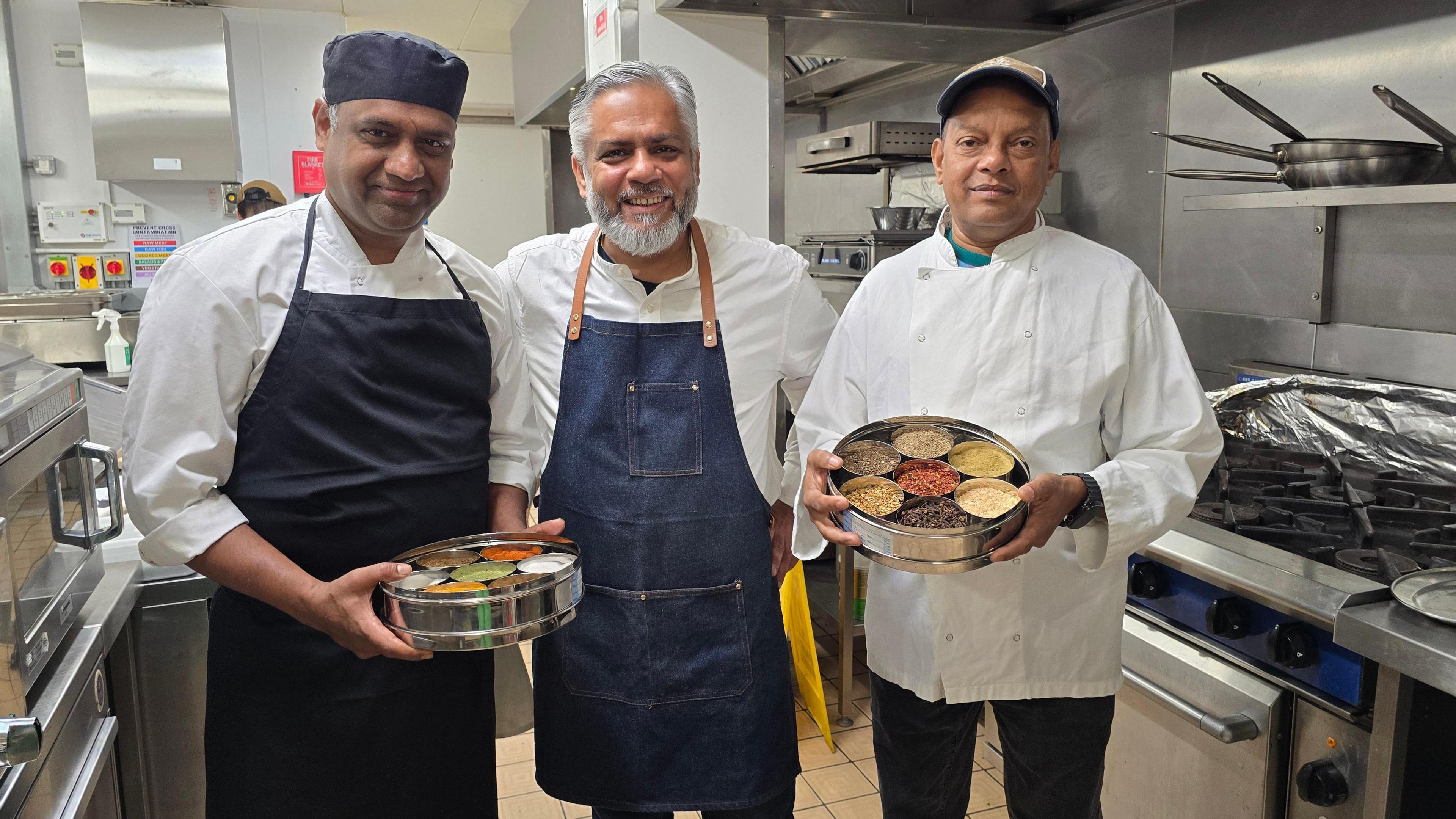 Vivek and some of his team ahead of the big opening standing in a hotel kitchen dressed in chef's whites and holding spices