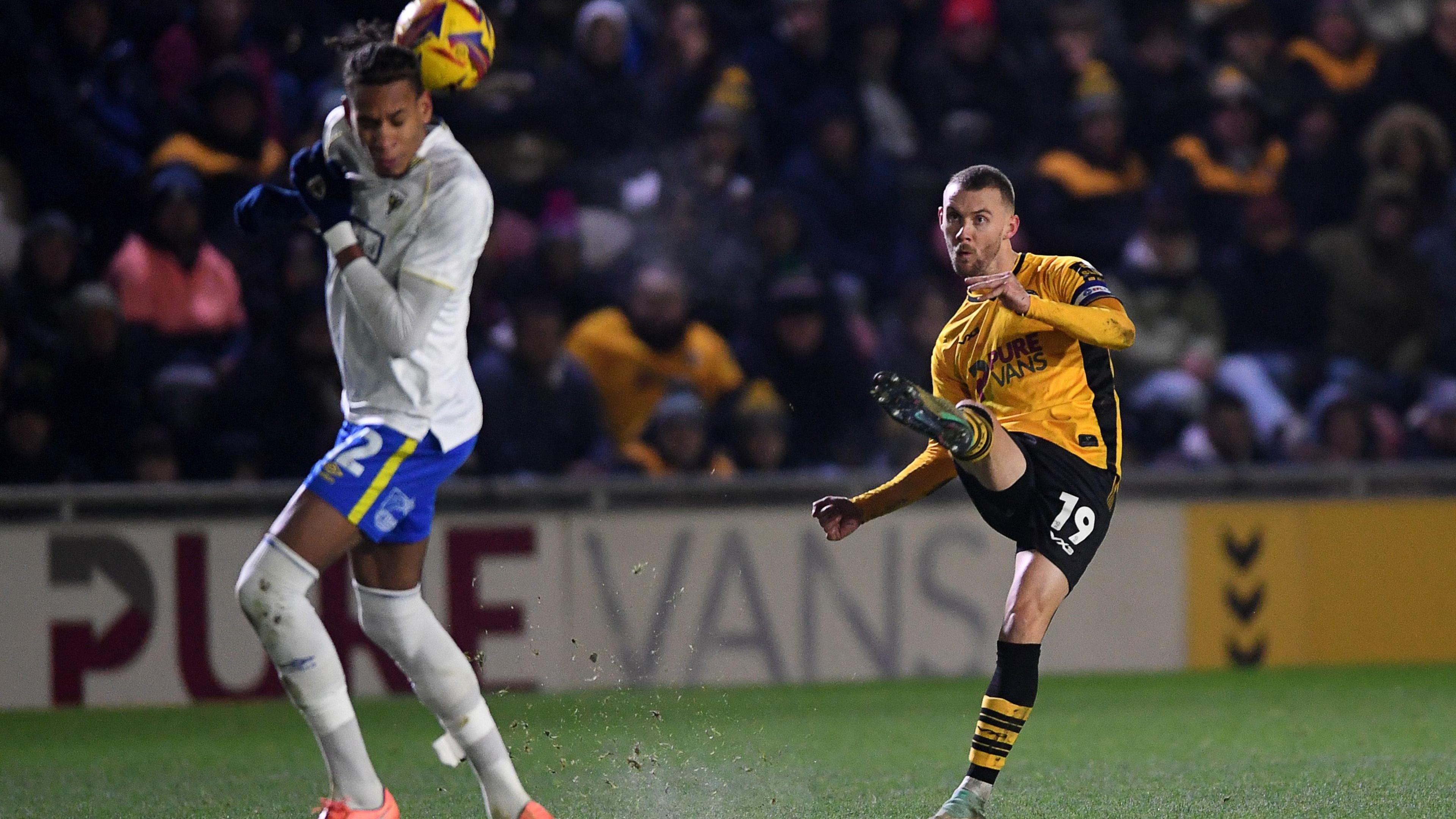 Shane McLoughlin of Newport County strikes the ball versus AFC Wimbledon