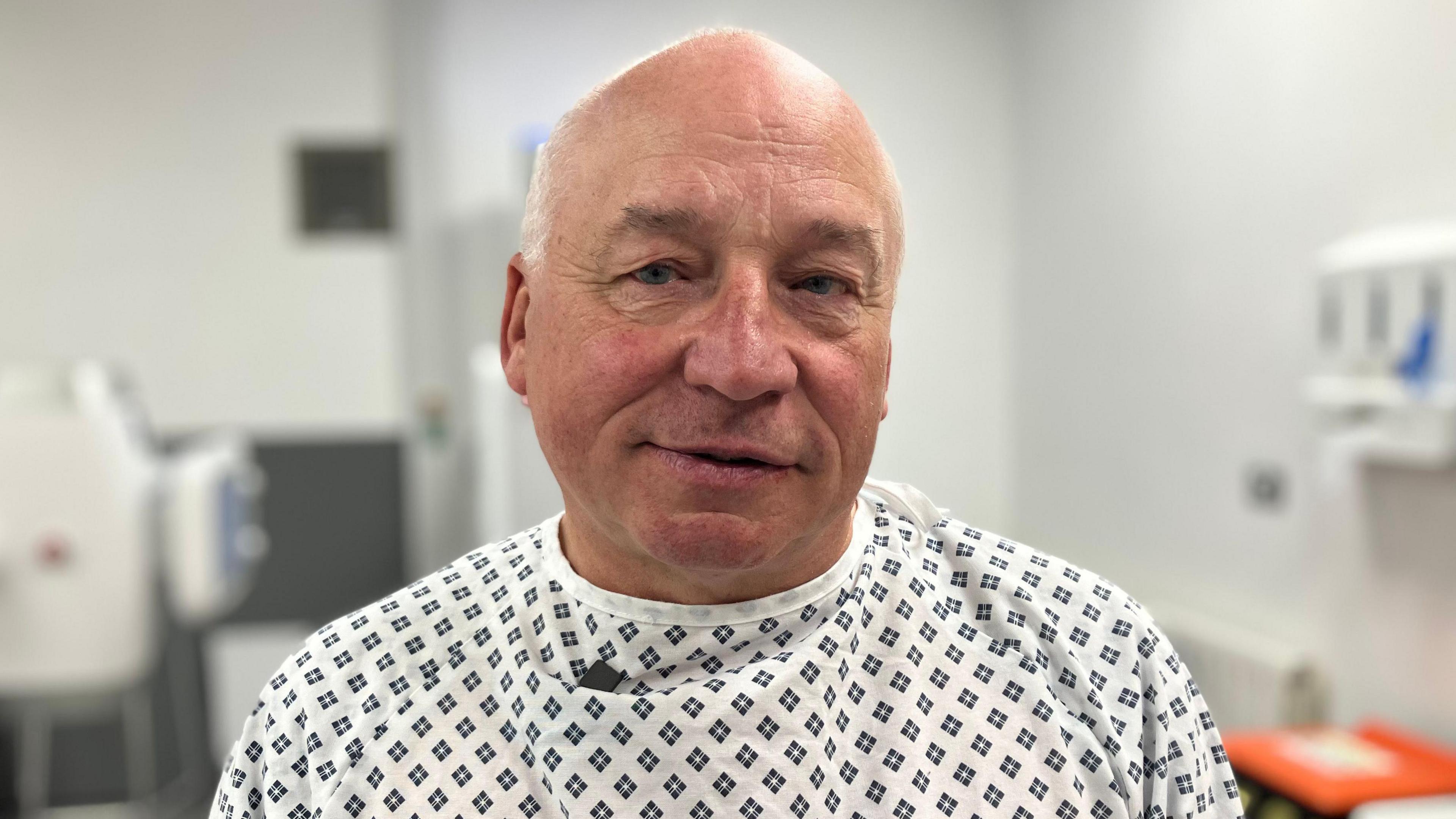 Peter Moult looks into the camera while wearing a hospital gown at Coalville Community Hospital