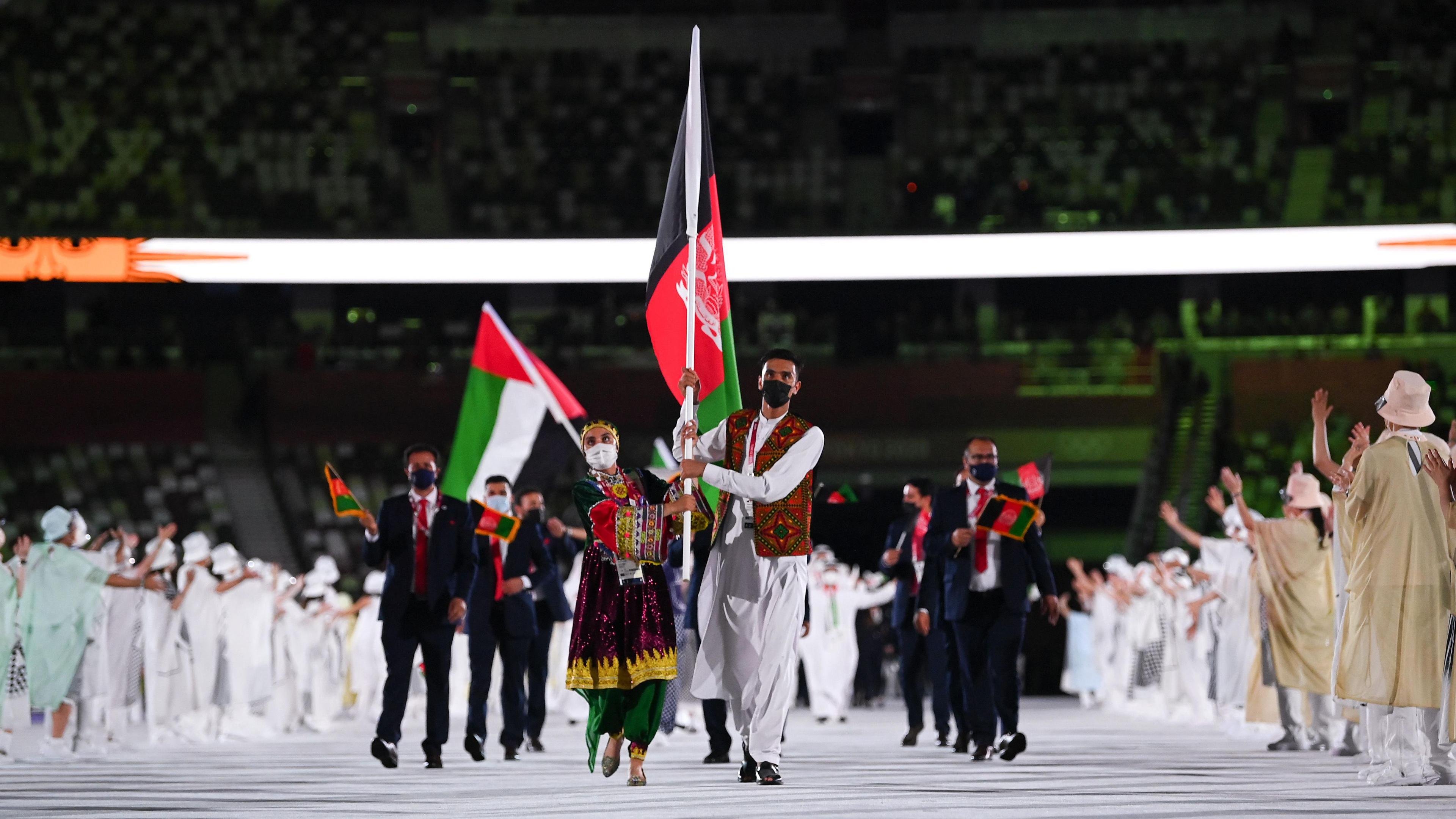 Afghanistan athletes enter the stadium through a gauntlet of welcoming volunteers