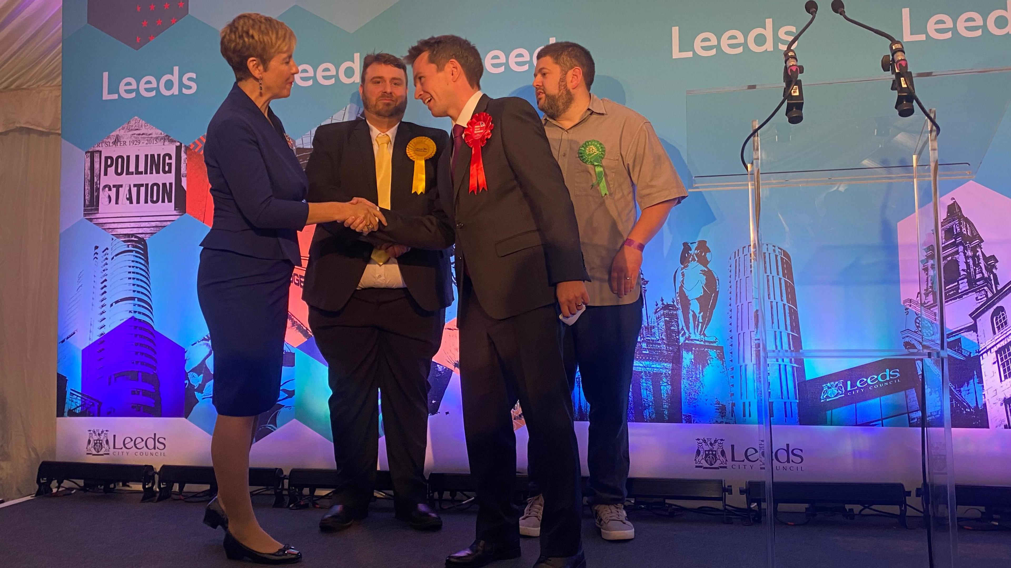 Mark Sewards shakes hands with Andrea Jenkyns at an election count. Behind them are candidates for the Liberal Democrats and the Green Party.