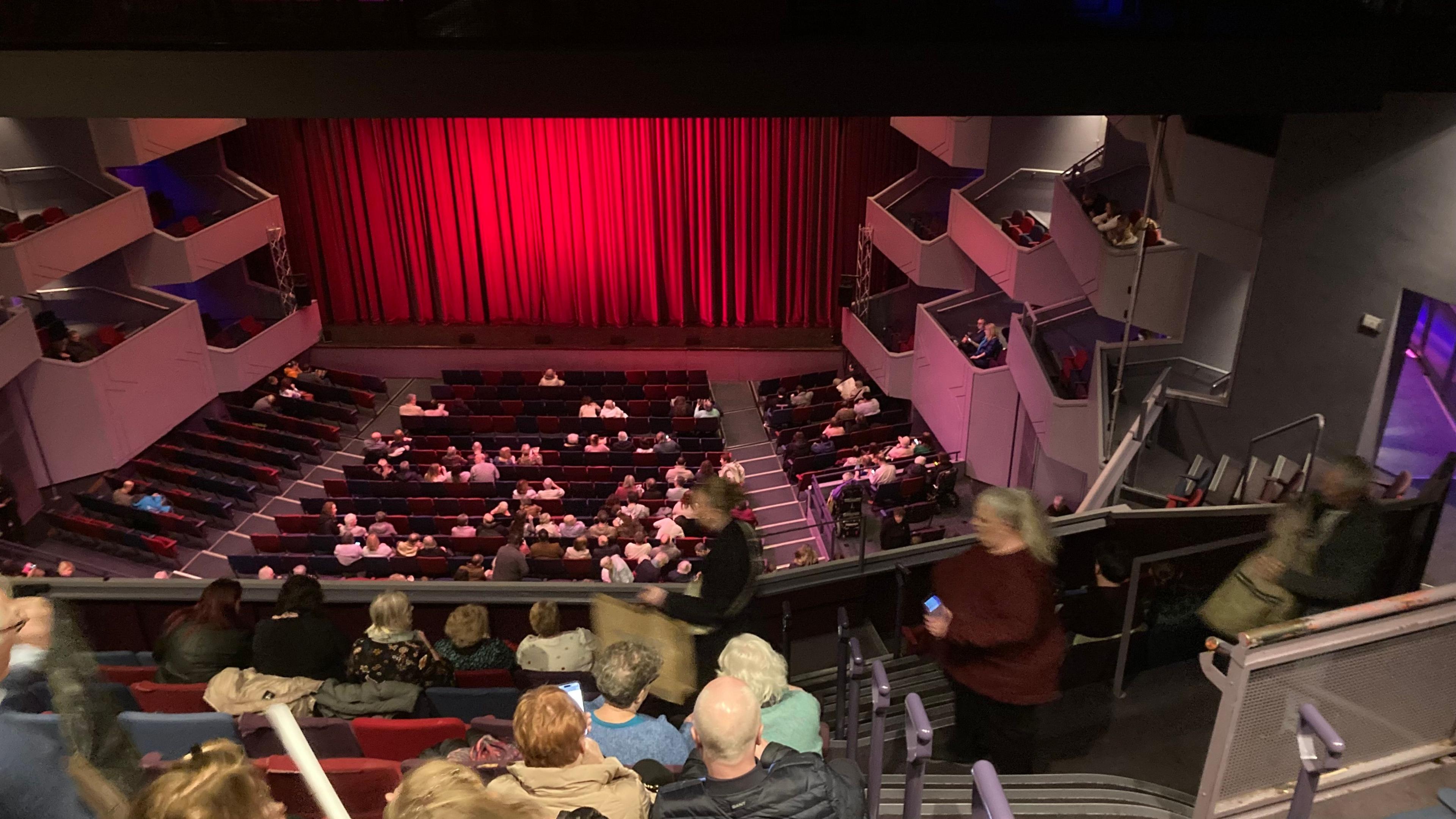 A number of people sitting in the Derngate auditorium waiting for a performance.