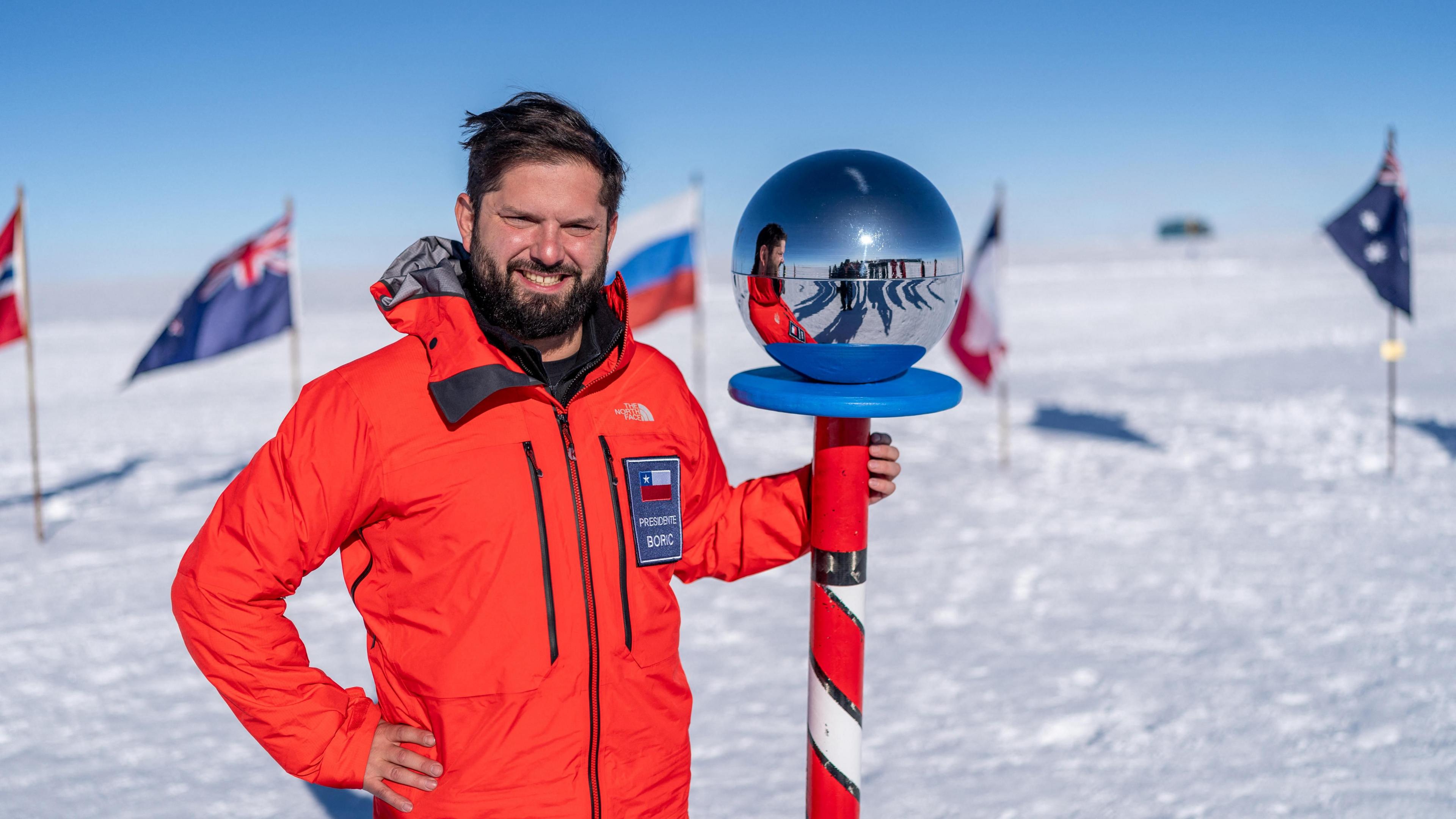 Chilean President Gabriel Boric poses next to the Ceremonial Pole Globe during his historic visit to the South Pole in Antarctica, on 3 January 2025