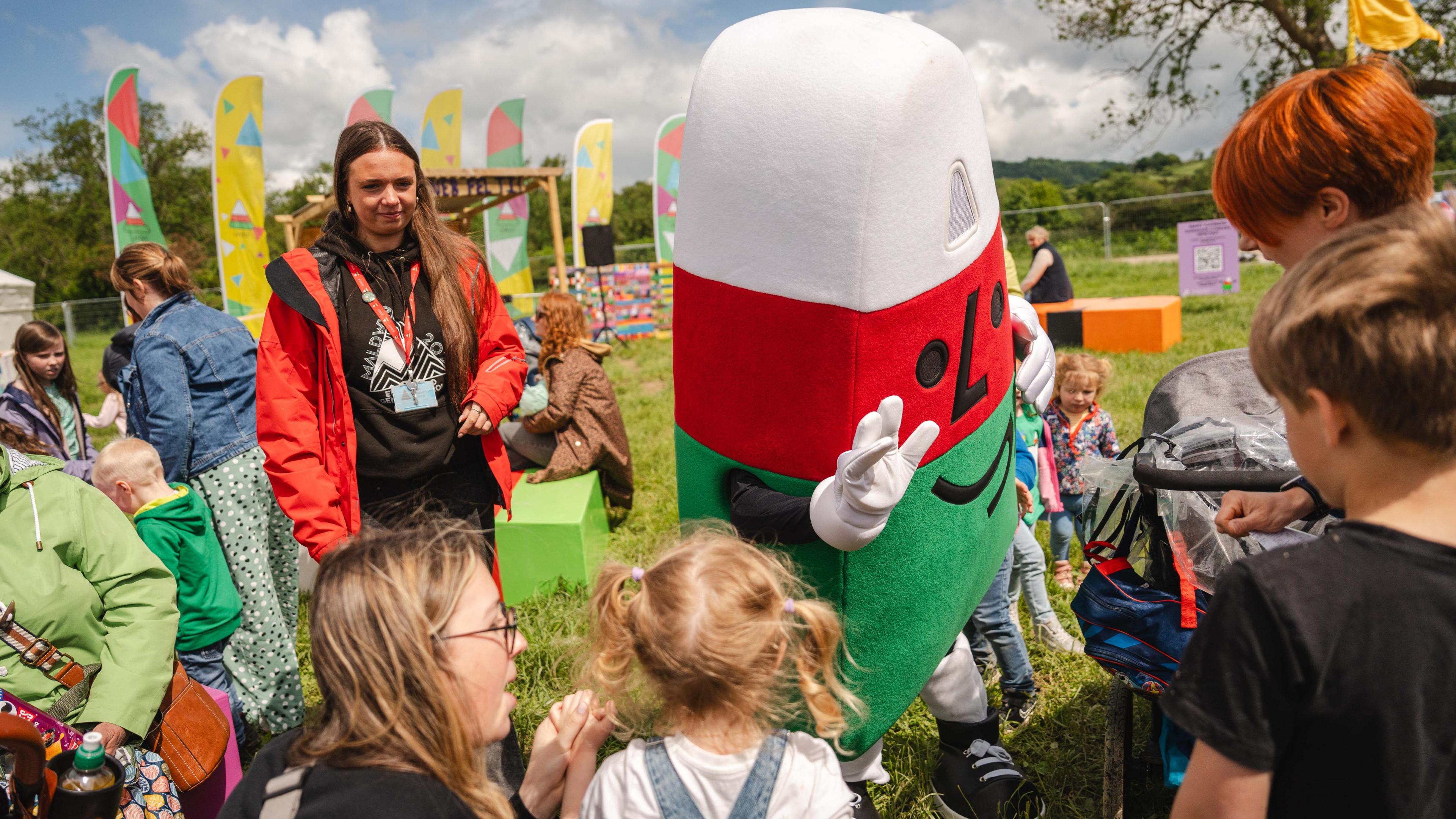 The Urdd's mascot Mistar Urdd waves to children.