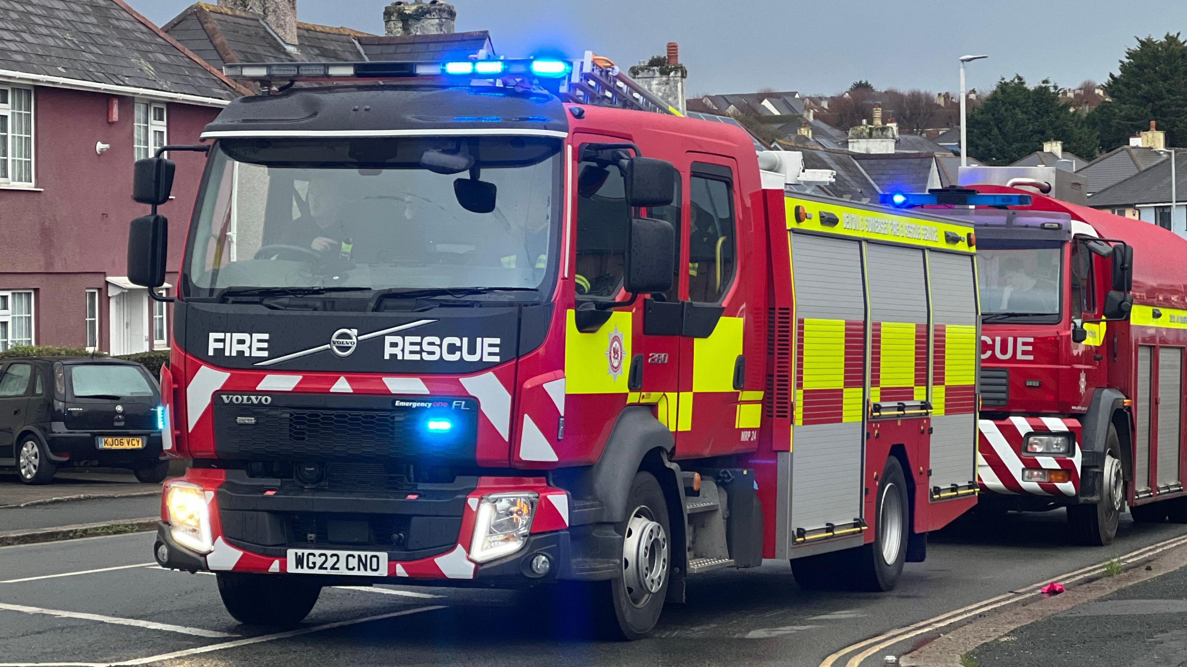 Two fire engines driving down the road. 