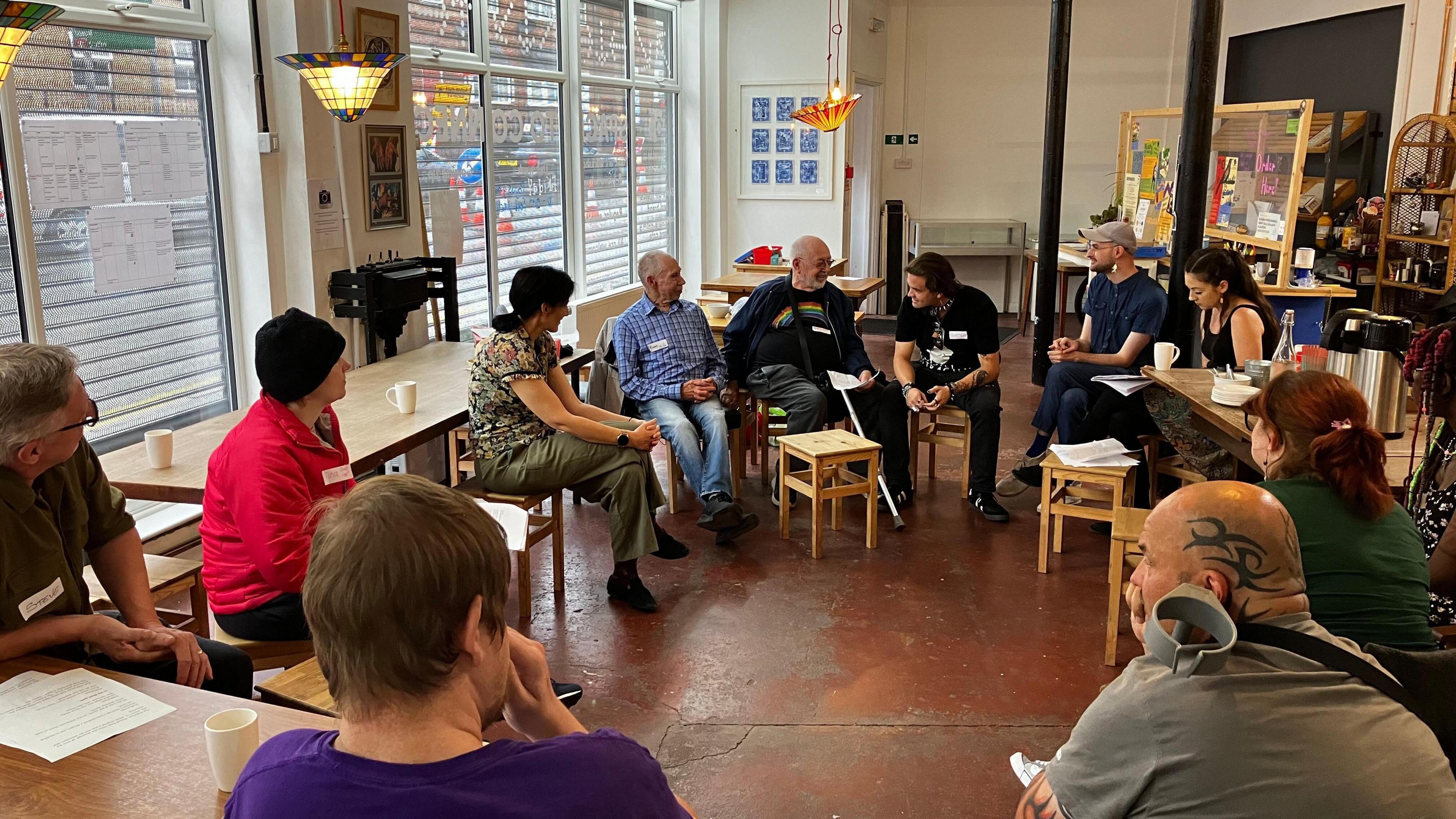 A group of people sitting in a circle with a few leaning into each other as if they were whispering to share some secrets or rumours.