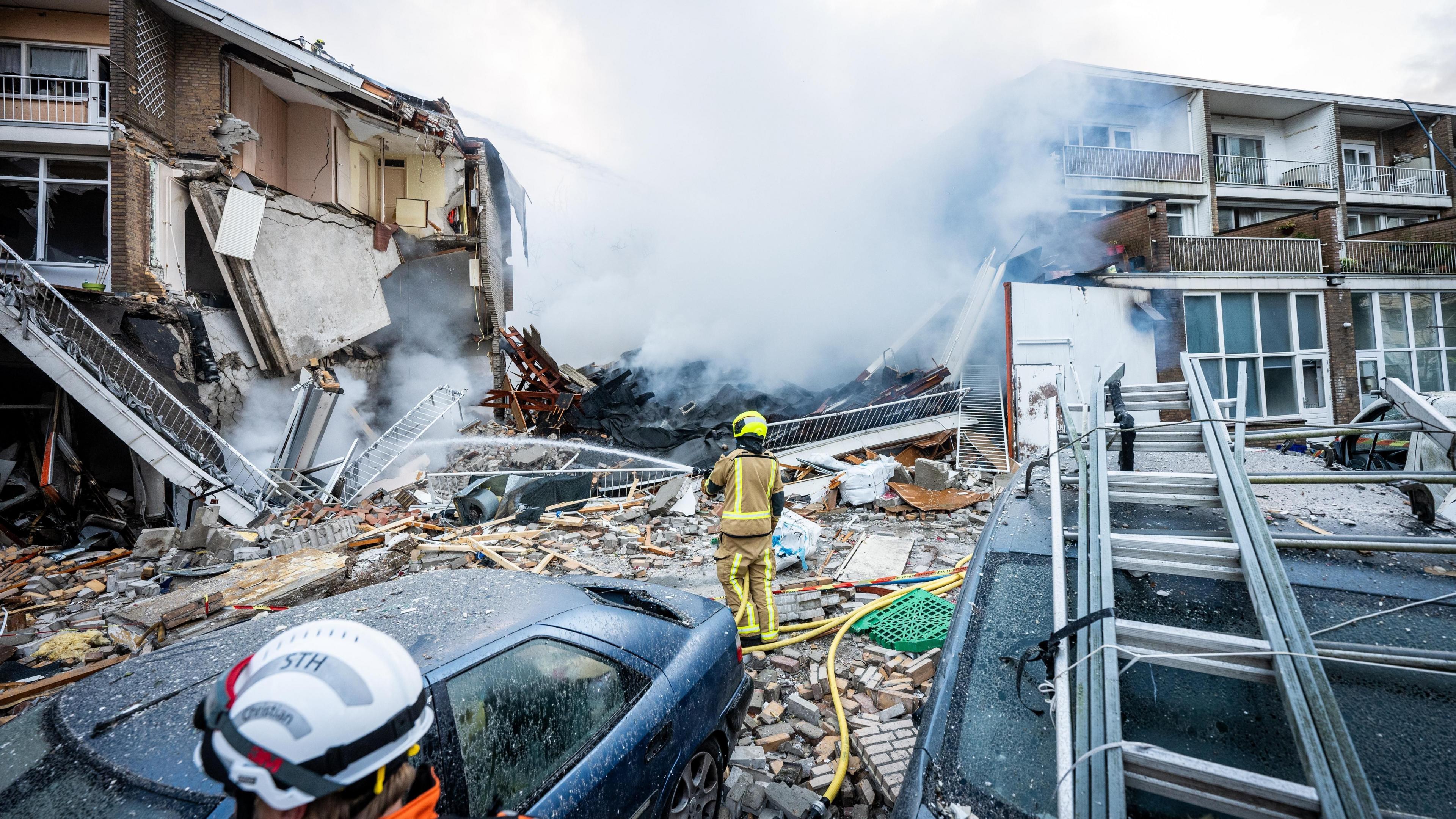 Firefighters putting out a fire after a building collapse.