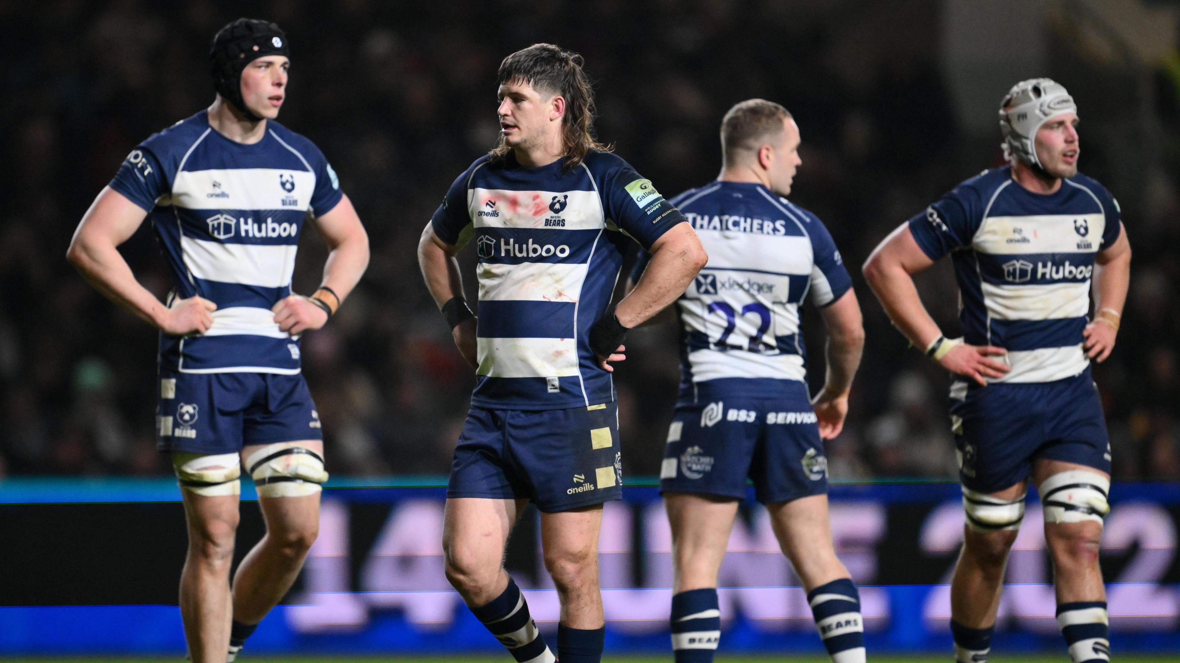 Bristol players stand on the Ashton Gate field, looking despondent