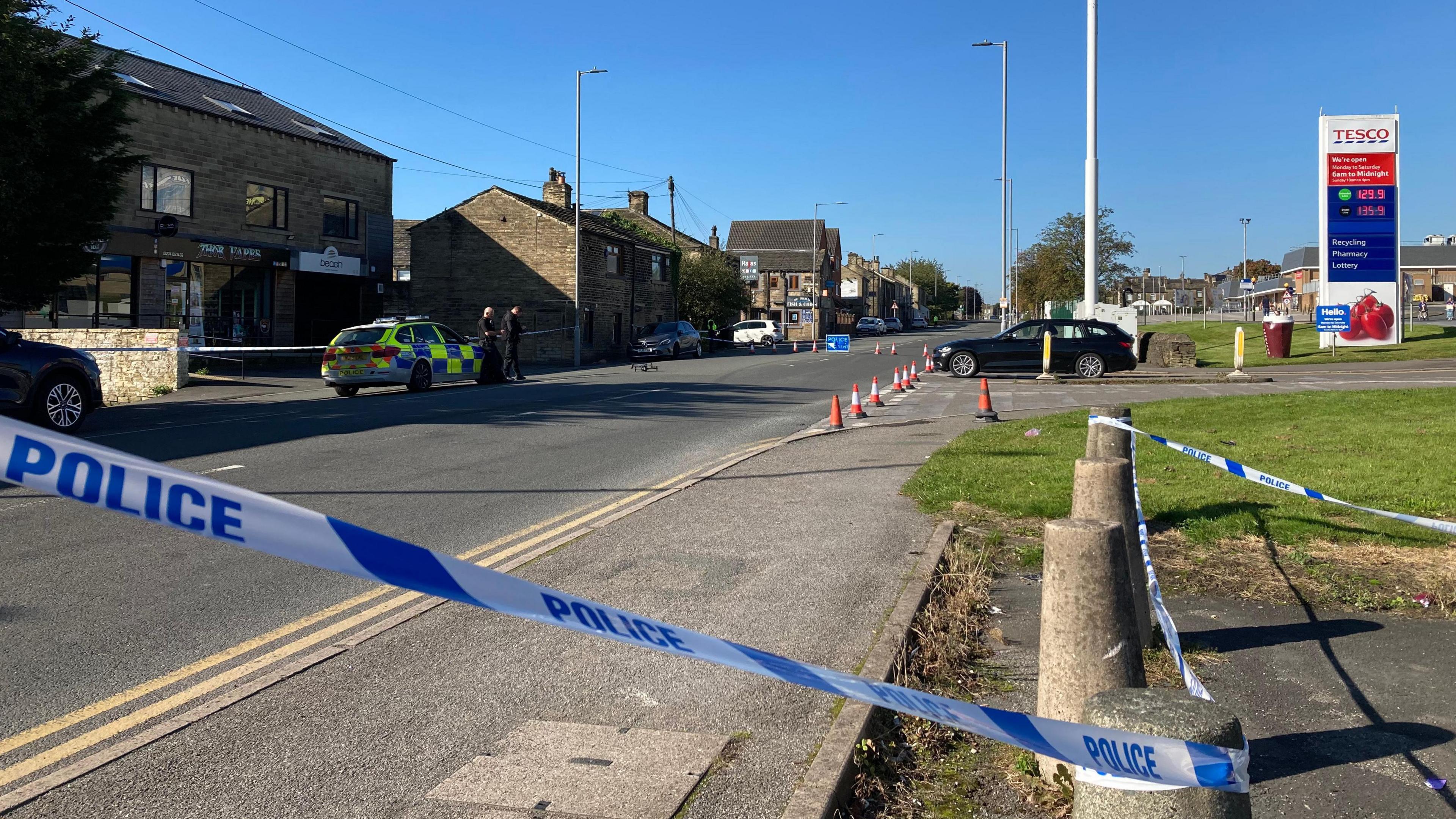 A view of Halifax Road in Bradford. Pictured is some police tape, indicating the road is closed, with a police car parked in the far distance