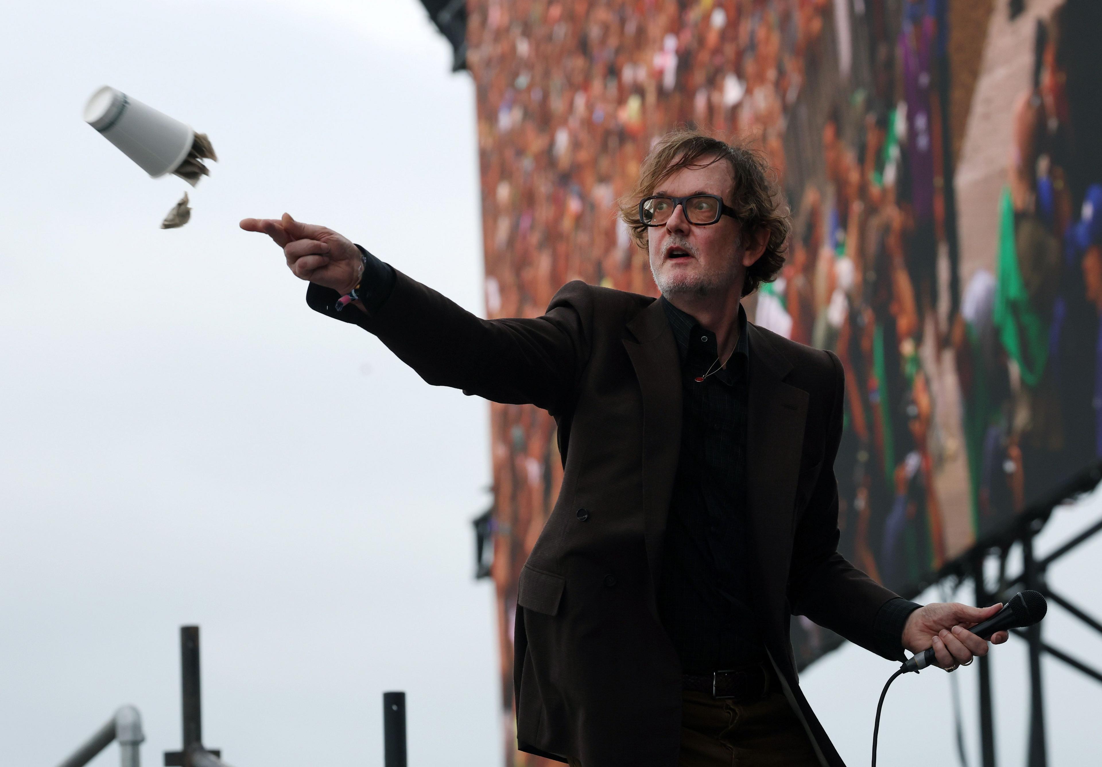 Jarvis Cocker throws a paper cup full of tea bags into the audience at the Glastonbury festival