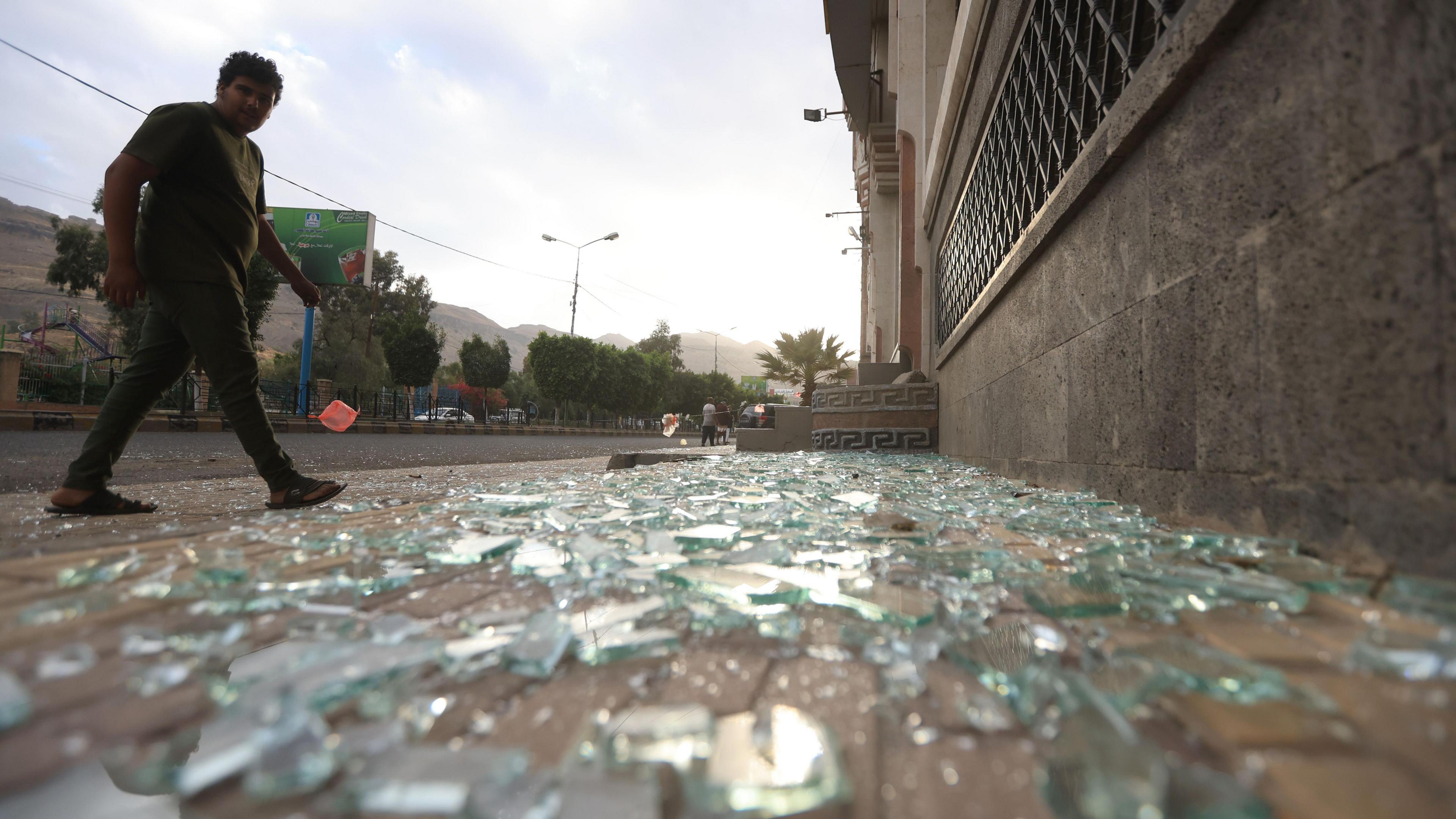 A person inspects the damage at a cordoned off area, a day after US airstrikes targeted a nearby position, in Sana'a, Yemen, on 16 March 2025