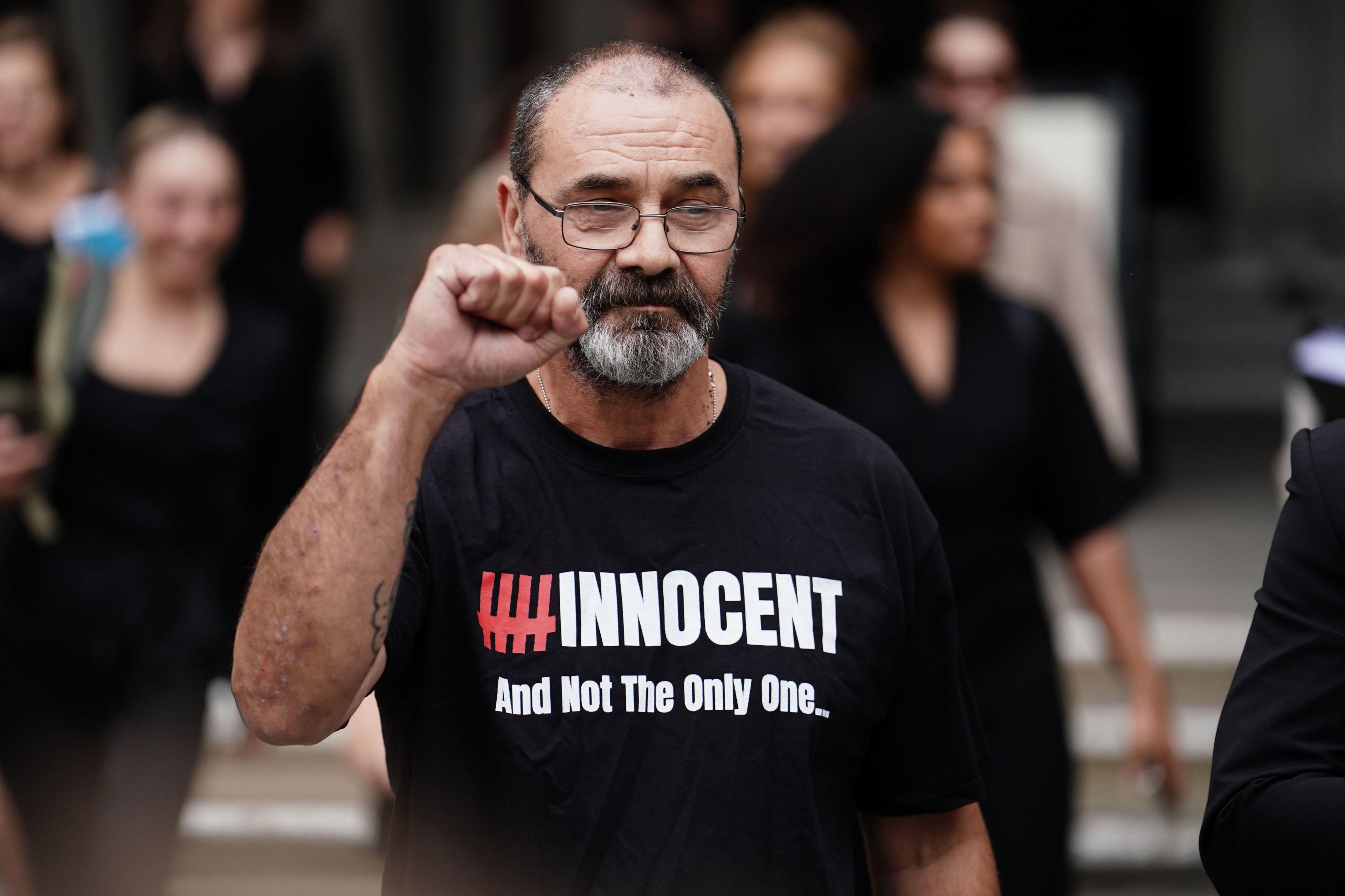 Andrew Malkinson stands with a clenched fist