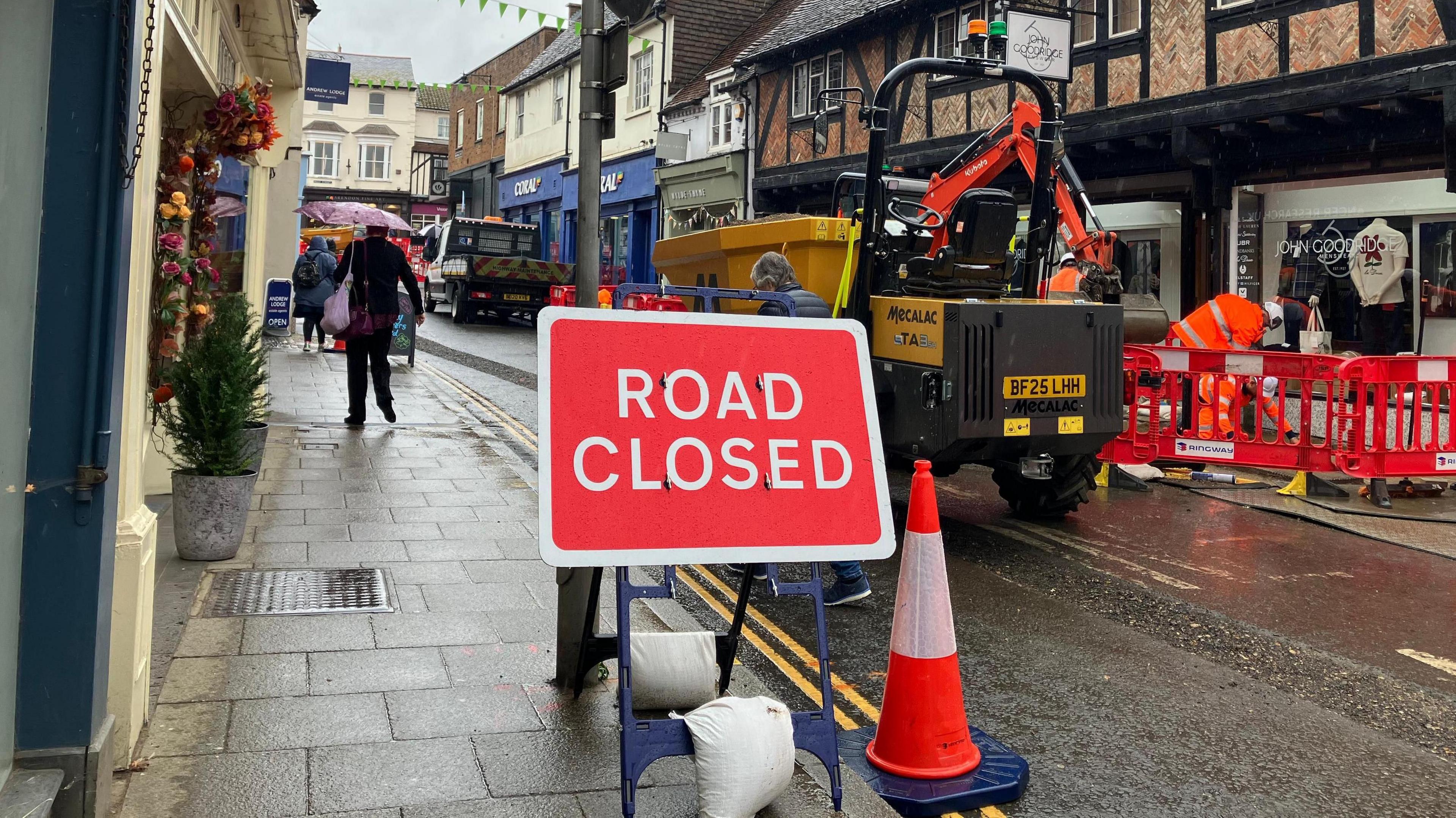 A road closed sign in Farnham town centre's roadworks. It is a rainy, grey day.