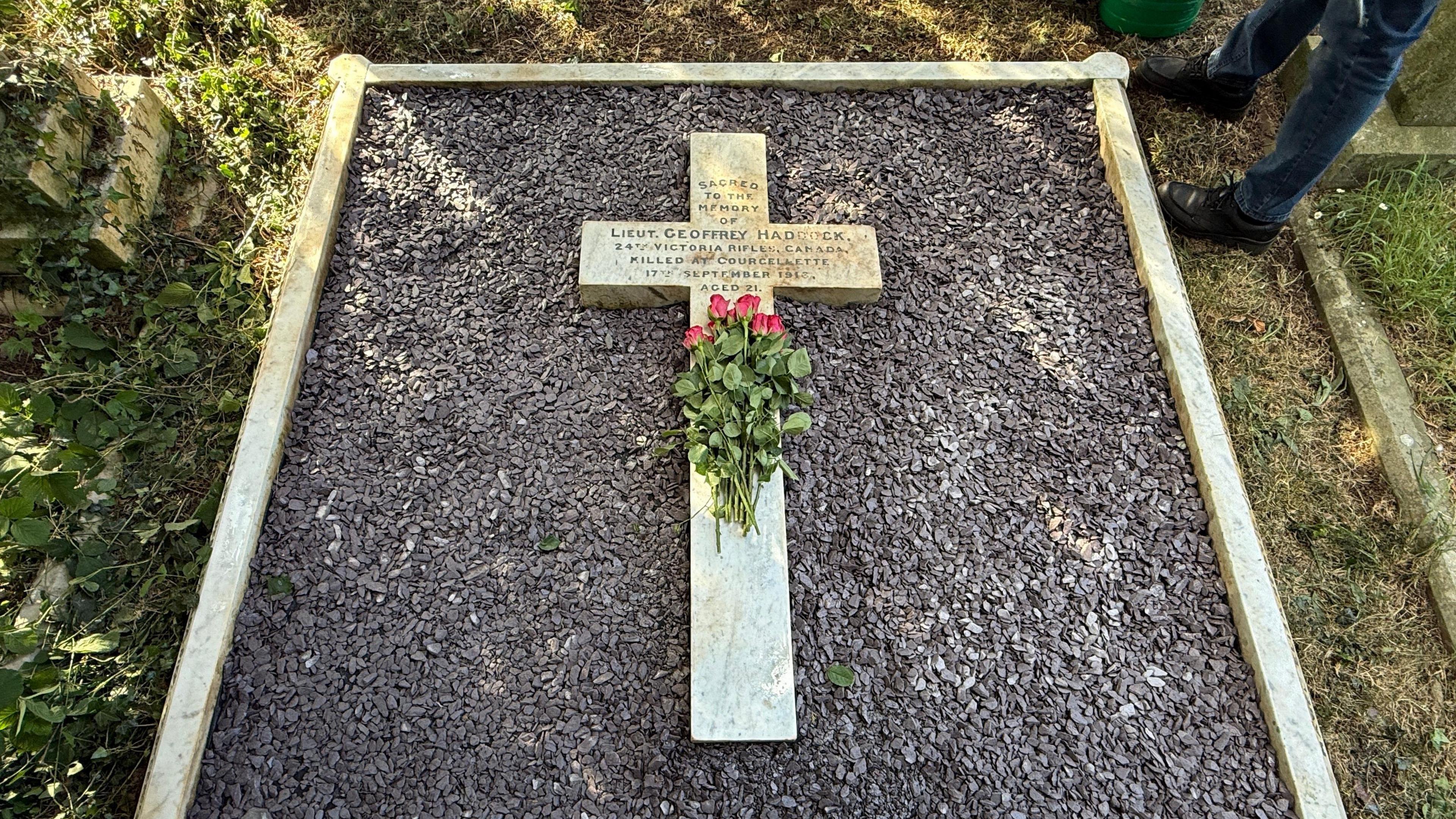 The grave of the first Titanic survivor, his and child. With a white marble cross and purple ceramic bits.