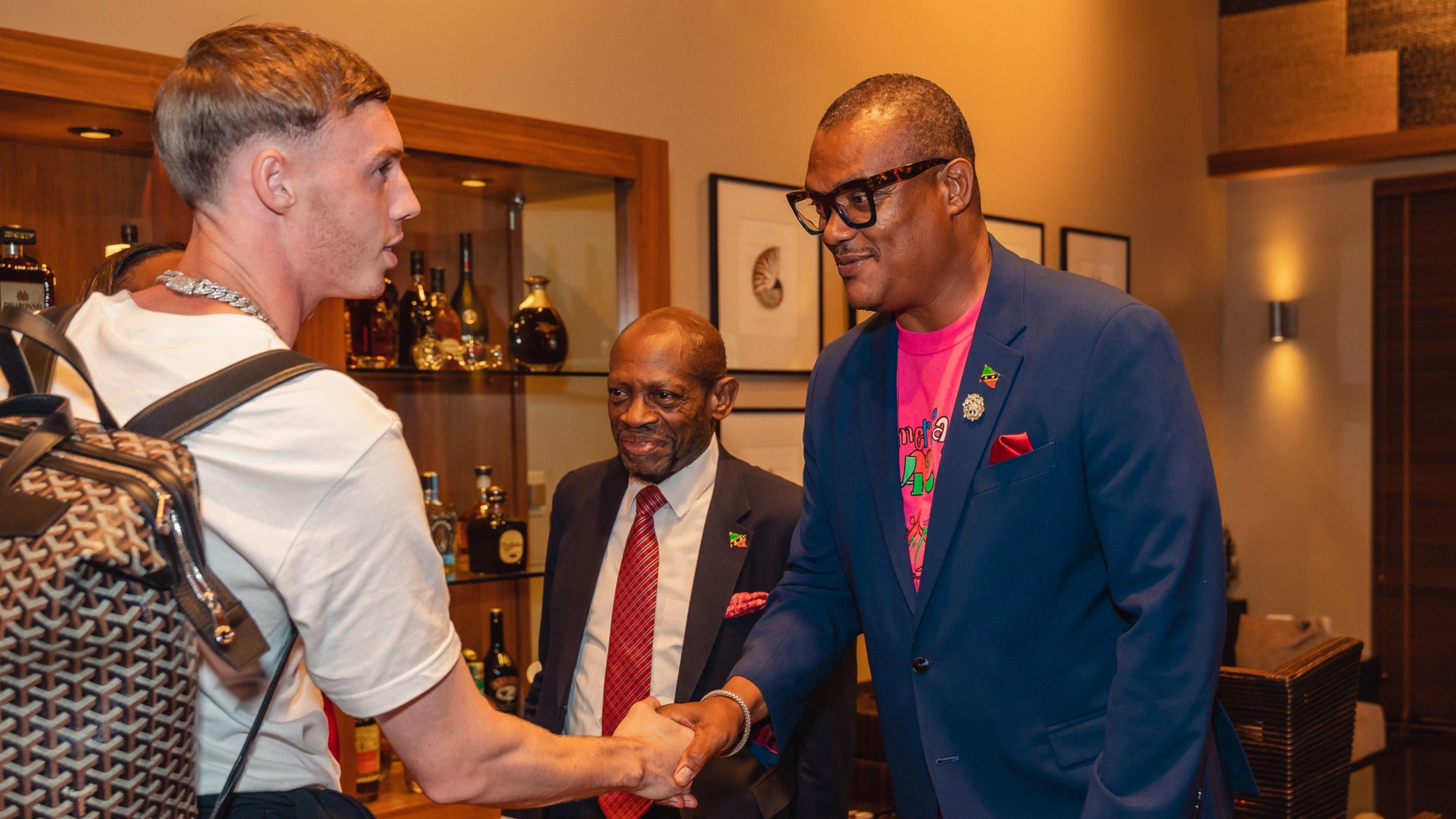Cole Palmer shakes hands with St Kitts' Deputy Prime Minister Geoffrey Hanley