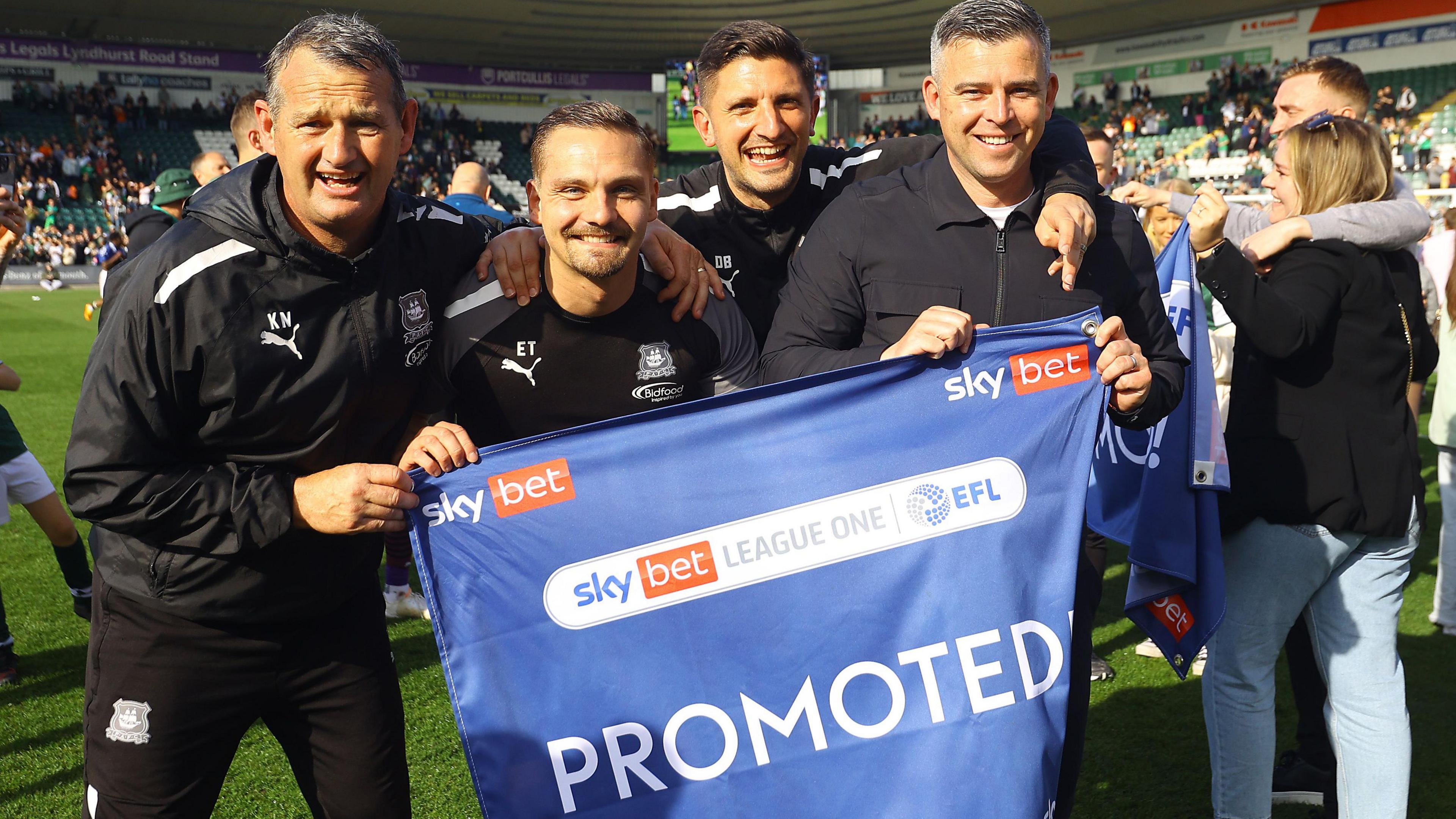 Steven Schumacher celebrates promotion with his Plymouth coaching staff