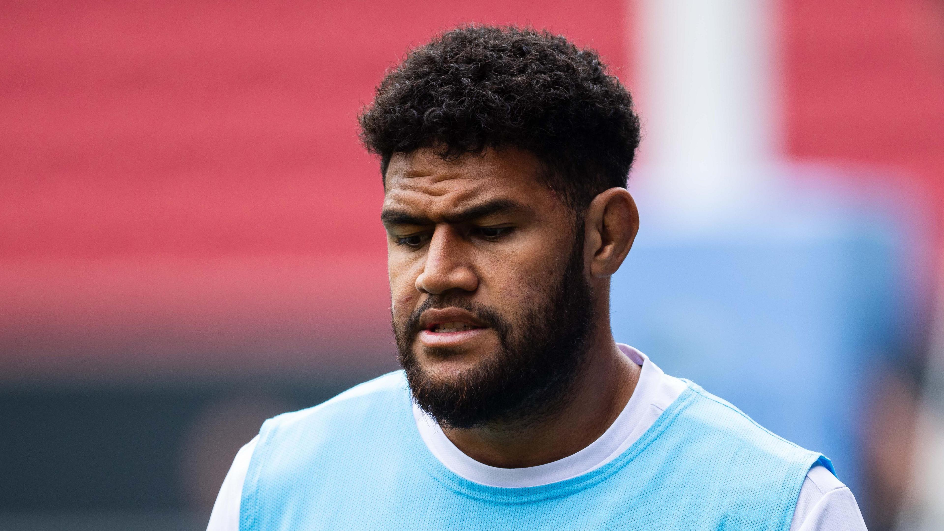 Rusi Tuima, wearing a blue bib over a white t-shirt, warming up for an Exeter match