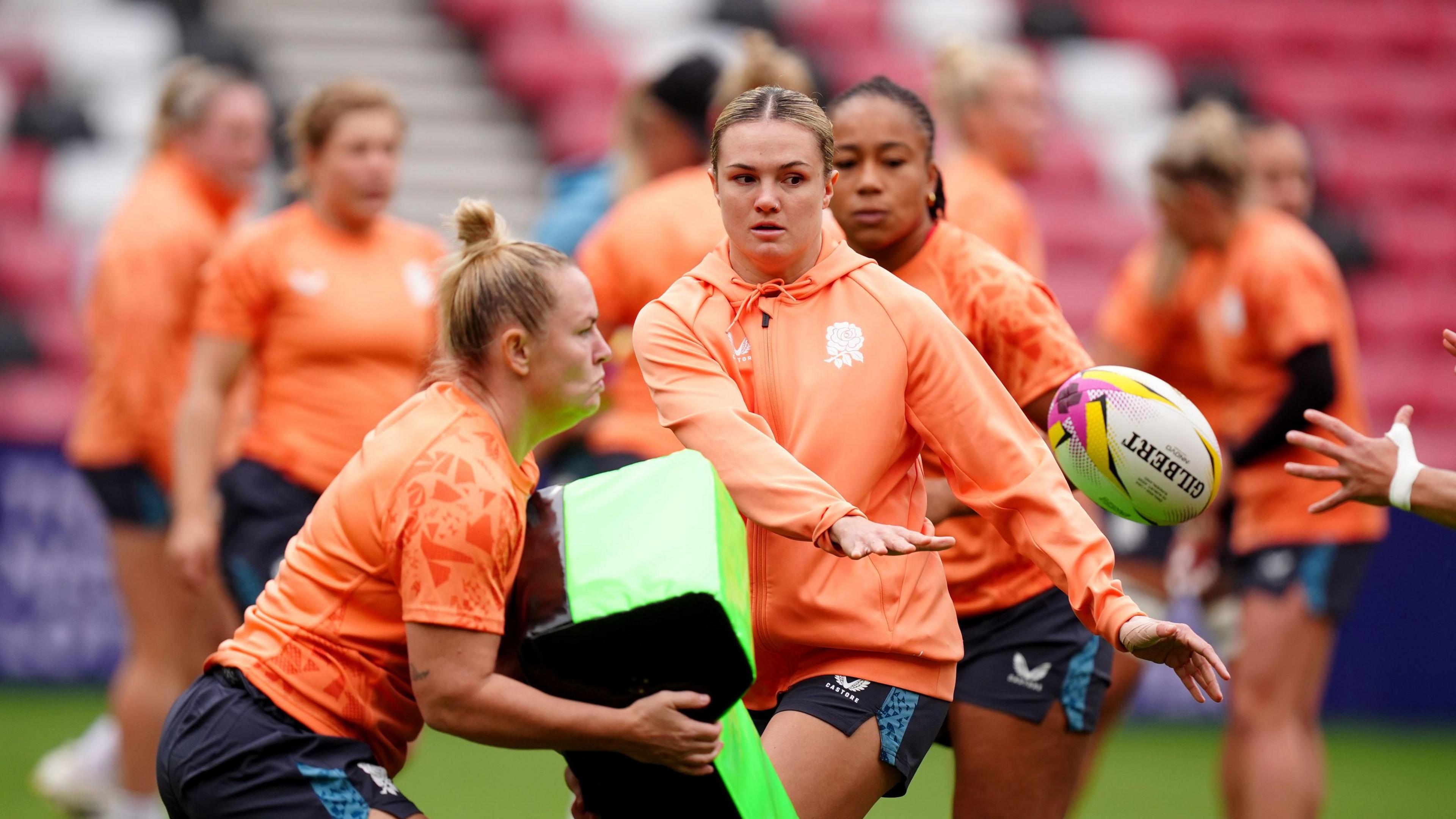 England's Ellie Kildunne during practice drills at the Stadium of Light, Sunderland ahead of the World Cup Match. She is passing the ball before she is hit by another player carrying a tackle pad.