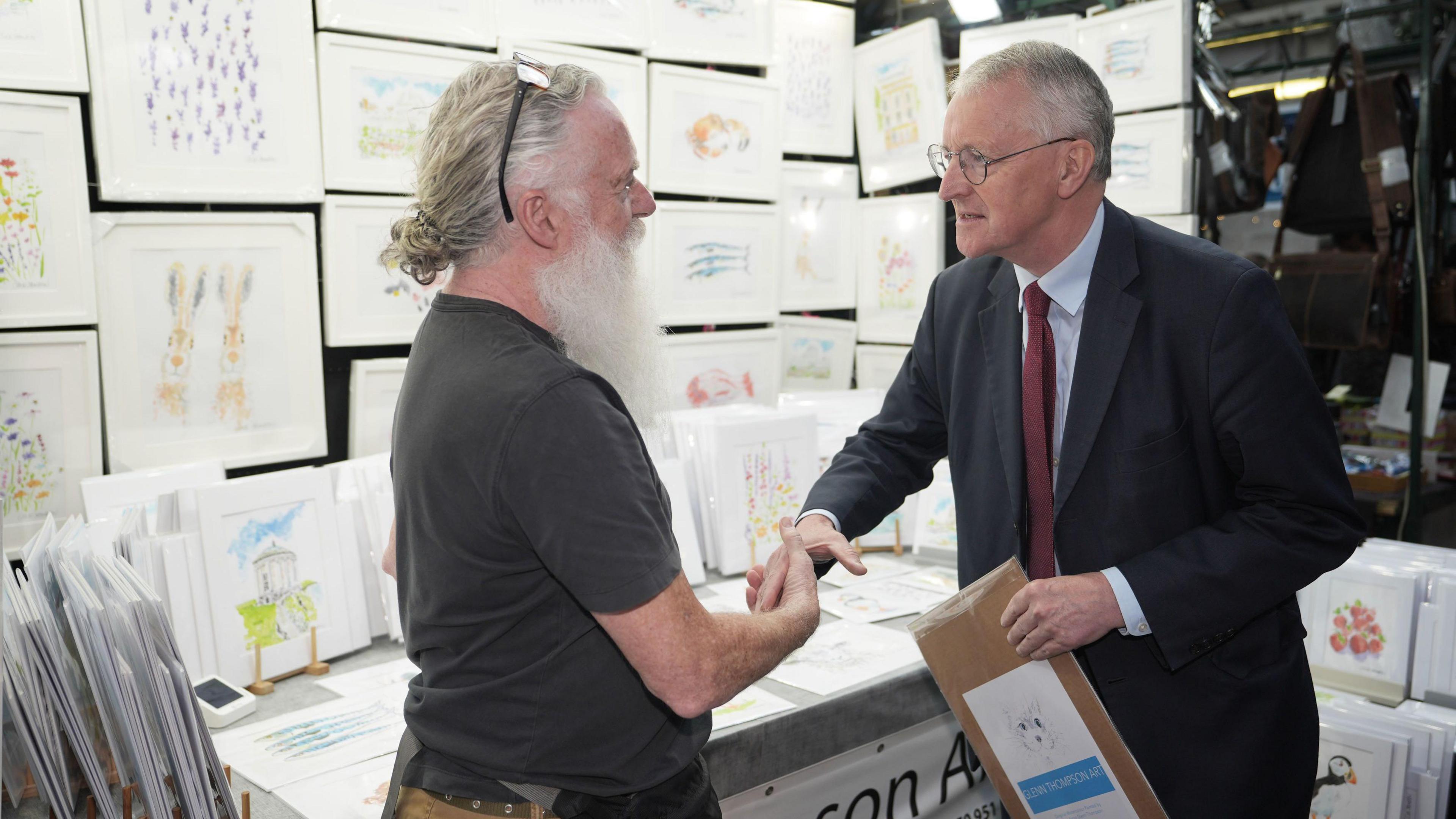 Northern Ireland Secretary Hilary Benn shakes hands with a market trader during a visit to St George's Market in Belfast