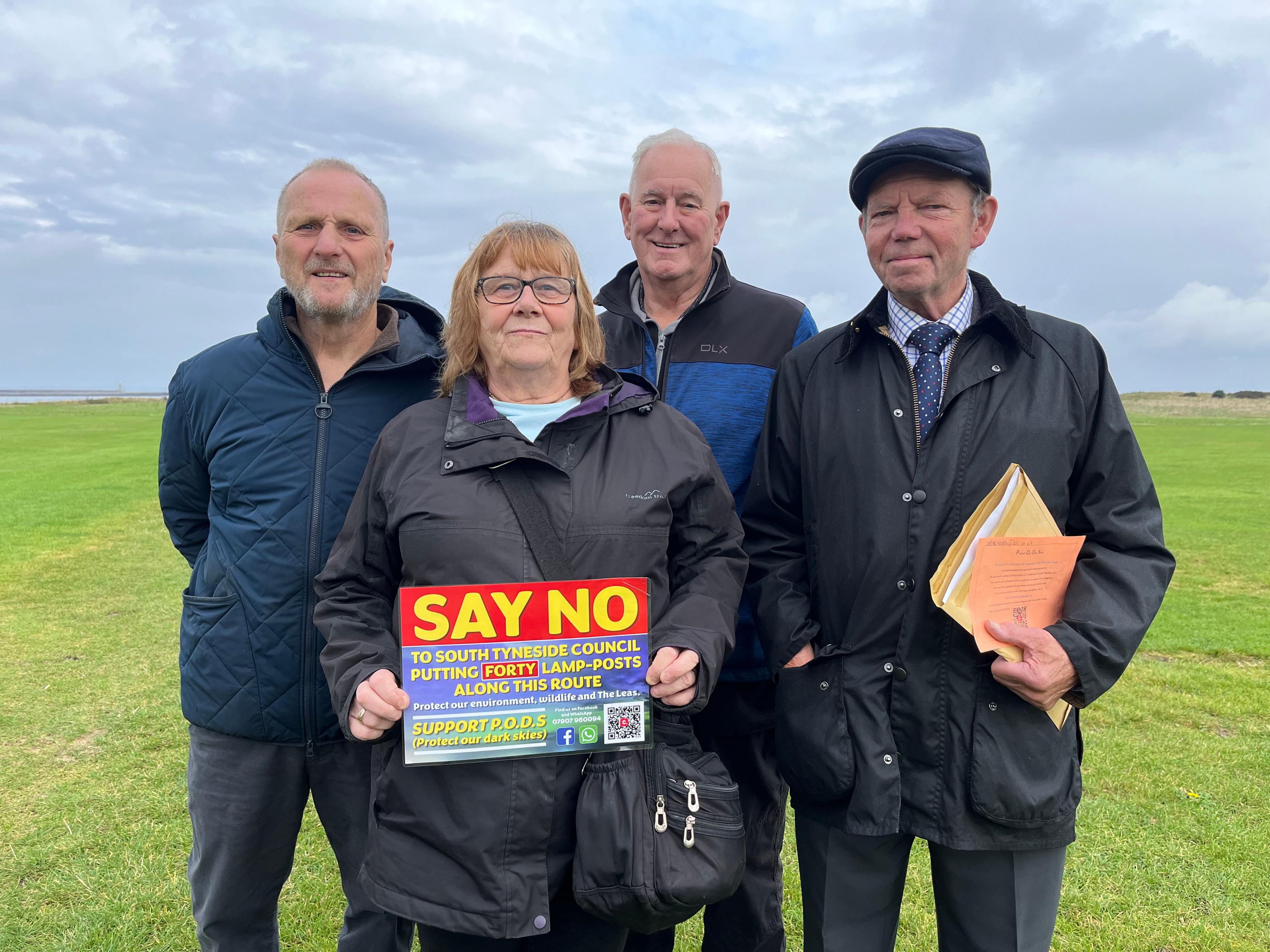 Campaigners stand on the Leas, holding up a sign which asks people to support their petition