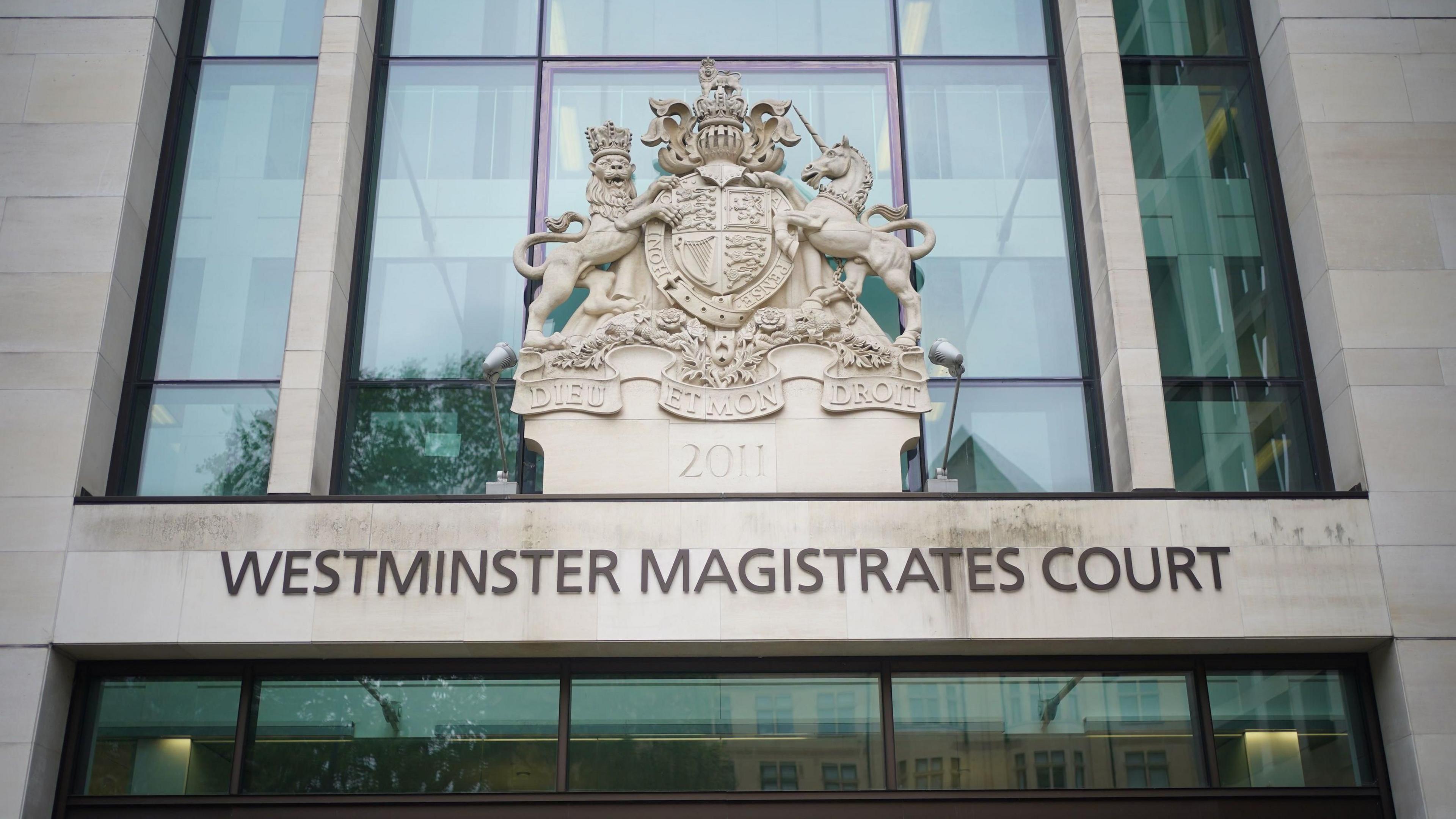 The entrance to Westminster Magistrates' Court, which has its name printed on the building. The building is a light colour with large glass windows.