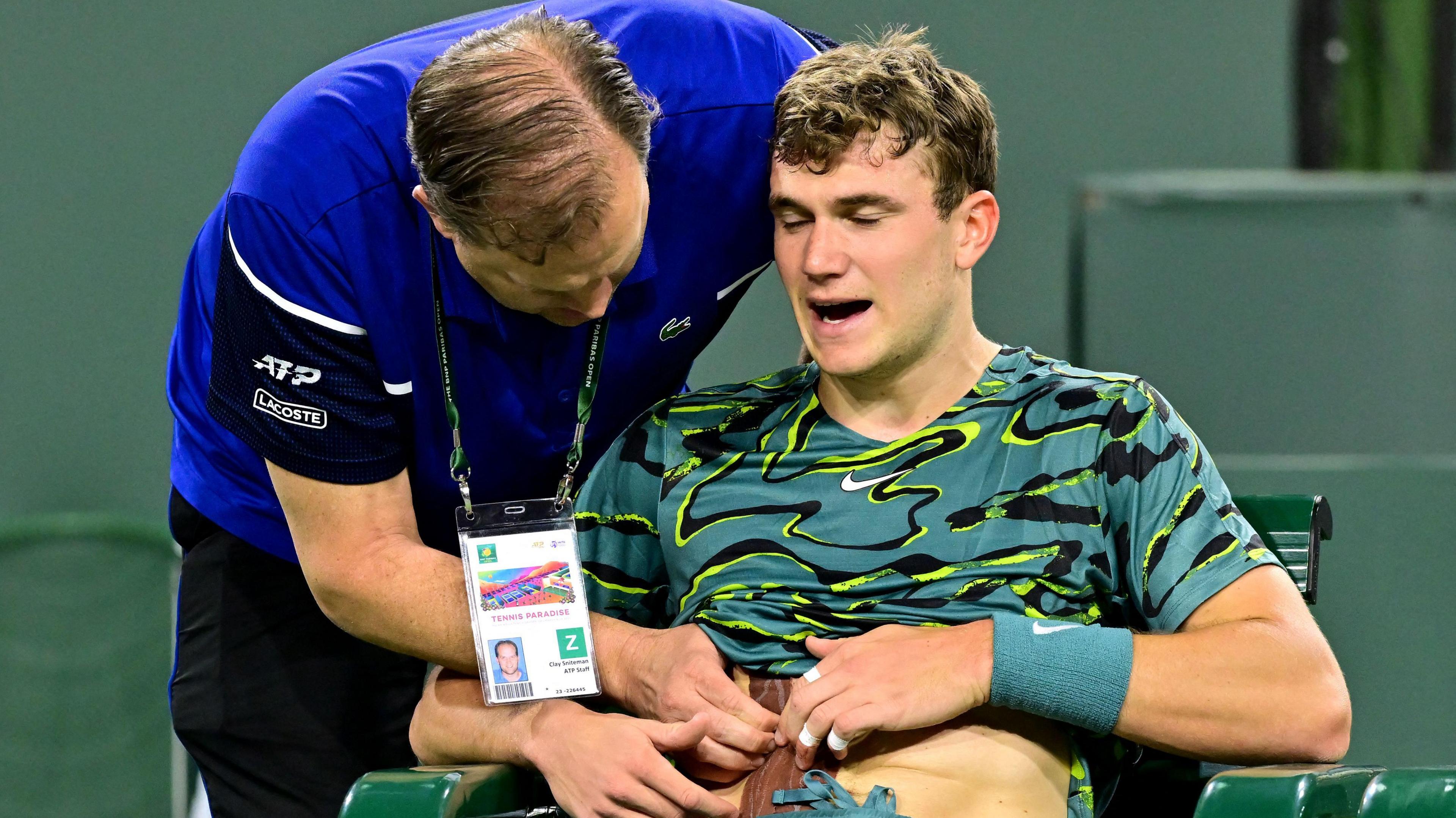 Britain's Jack Draper receives treatment for an abdominal injury before retiring midway through a match against Carlos Alcaraz at Indian Wells