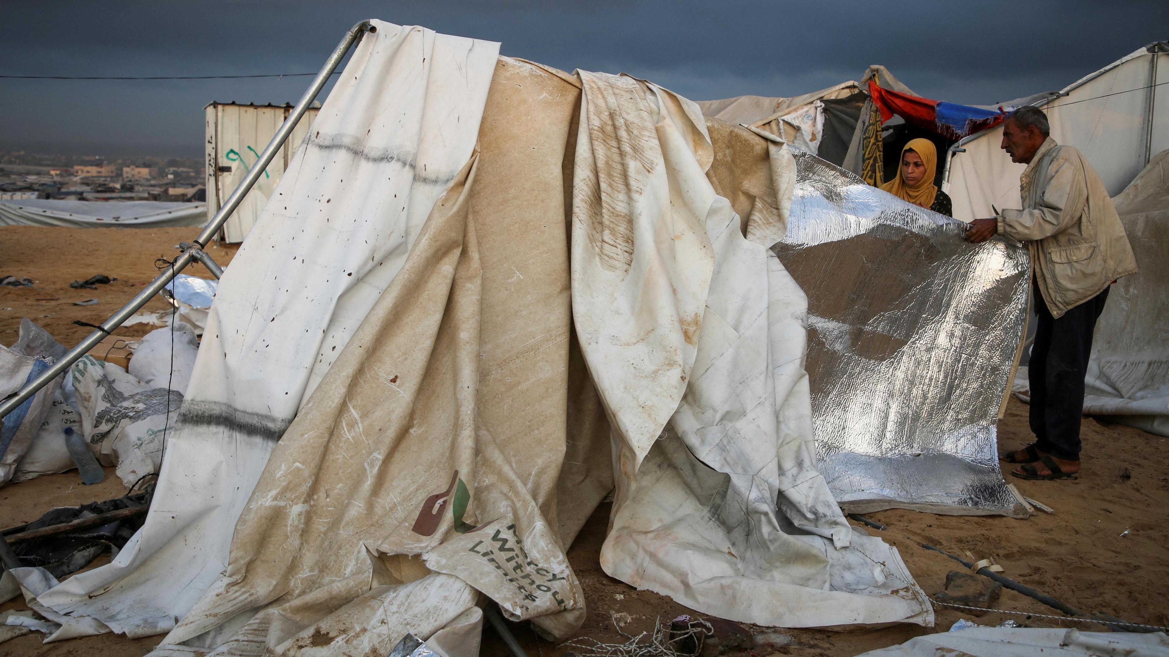 Displaced Palestinians inspect damage to their tent after an Israeli strike, in the al-Mawasi area, in the southern Gaza Strip (15 October 2024)