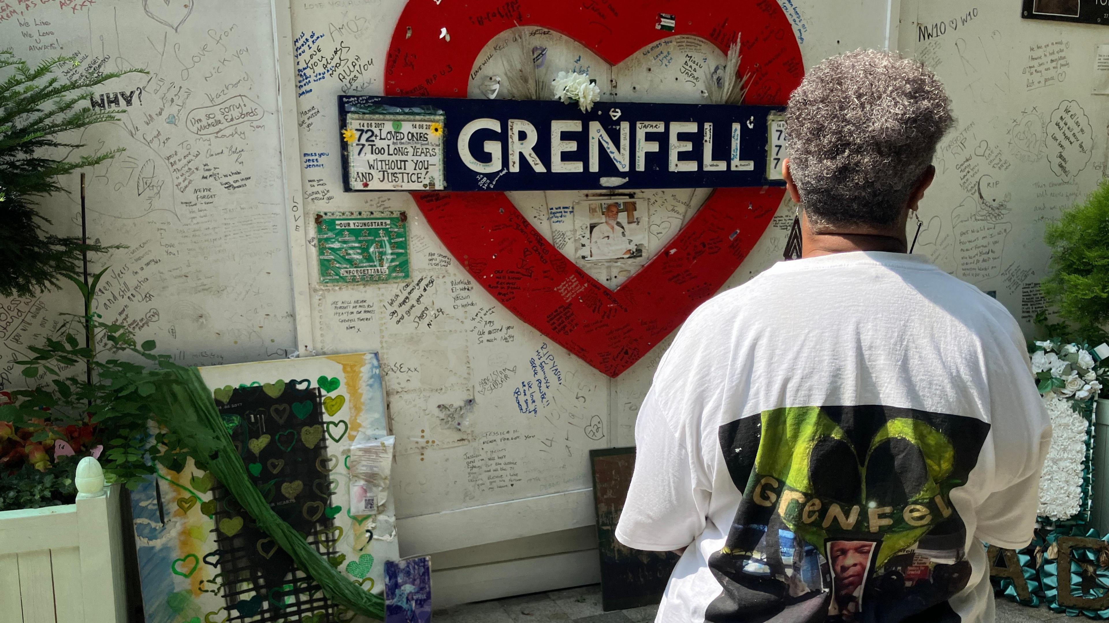 A woman looks at wall of tributes to Grenfell victims 